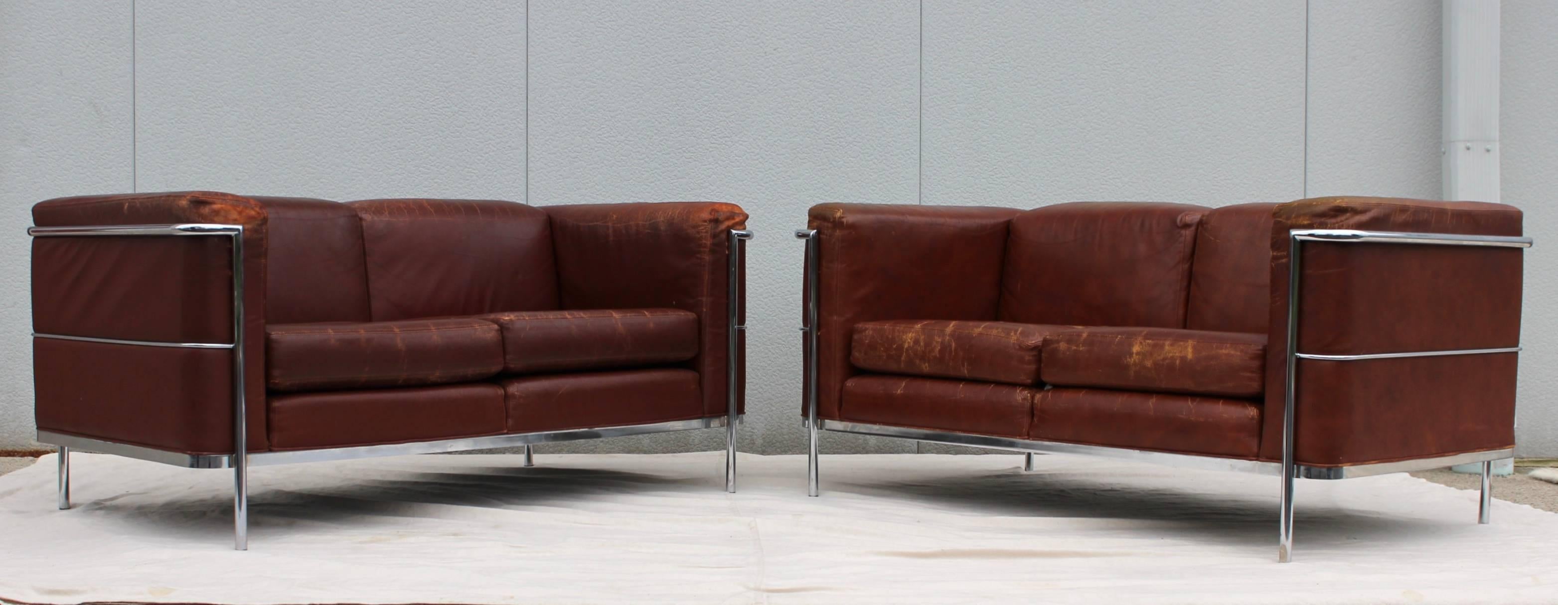 Stunning pair of 1980s distressed leather with chrome frame loveseats by Jack Cartwright. 

Matching pair of chairs and sofa is also available.