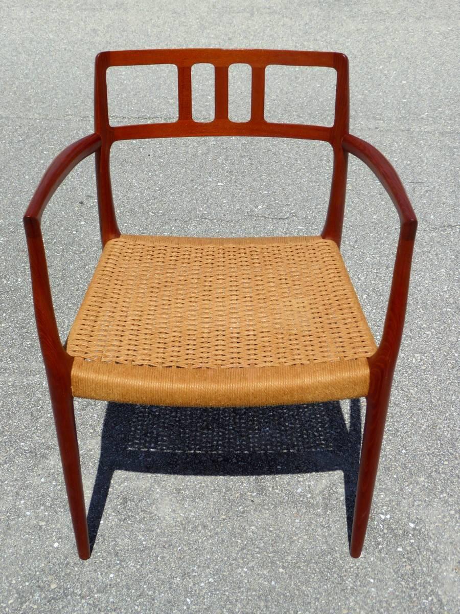 A marvelous model 64 armchair in teak, with a woven papercord seat. Designed by Niels Otto Møller for J.L. Møller Models. Bears the 
