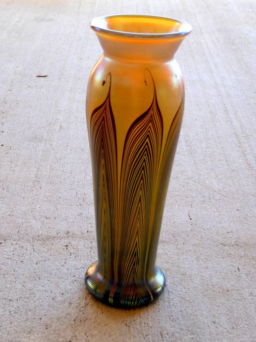 Lundberg studios art glass creations are often compared to those of Louis Comfort Tiffany. This one features a pulled feather design in iridescent gold tones reminiscent of favrile glass.

A few important notes about all items available through this