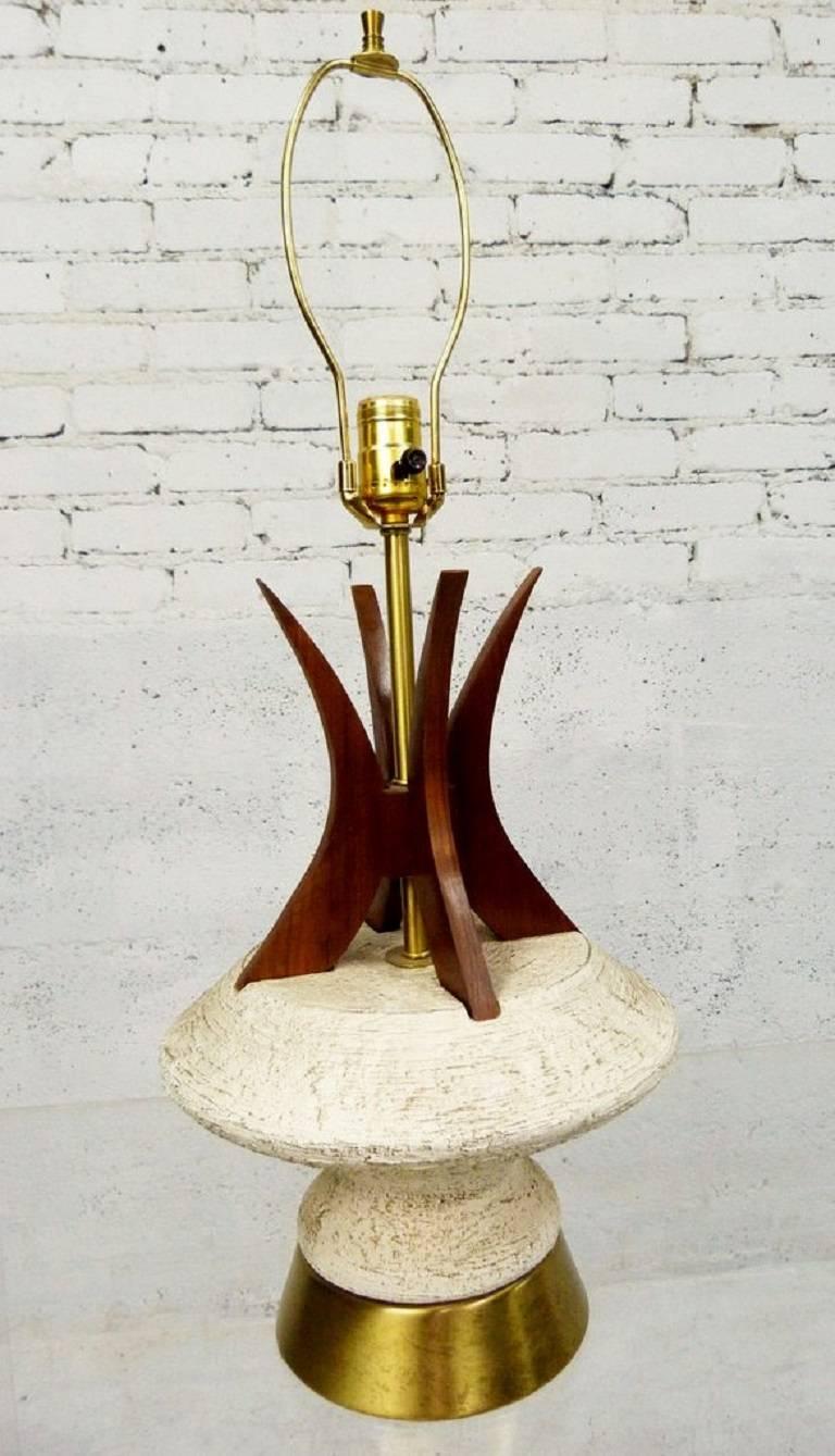 You don't often see a pair of 1950s lamps with intact tower shades. These teak, brass and chalkware examples by Plasto Mfg. Co. are magnificent, don't you think?

A few important notes about all items available through this 1stdibs dealer:

1. We
