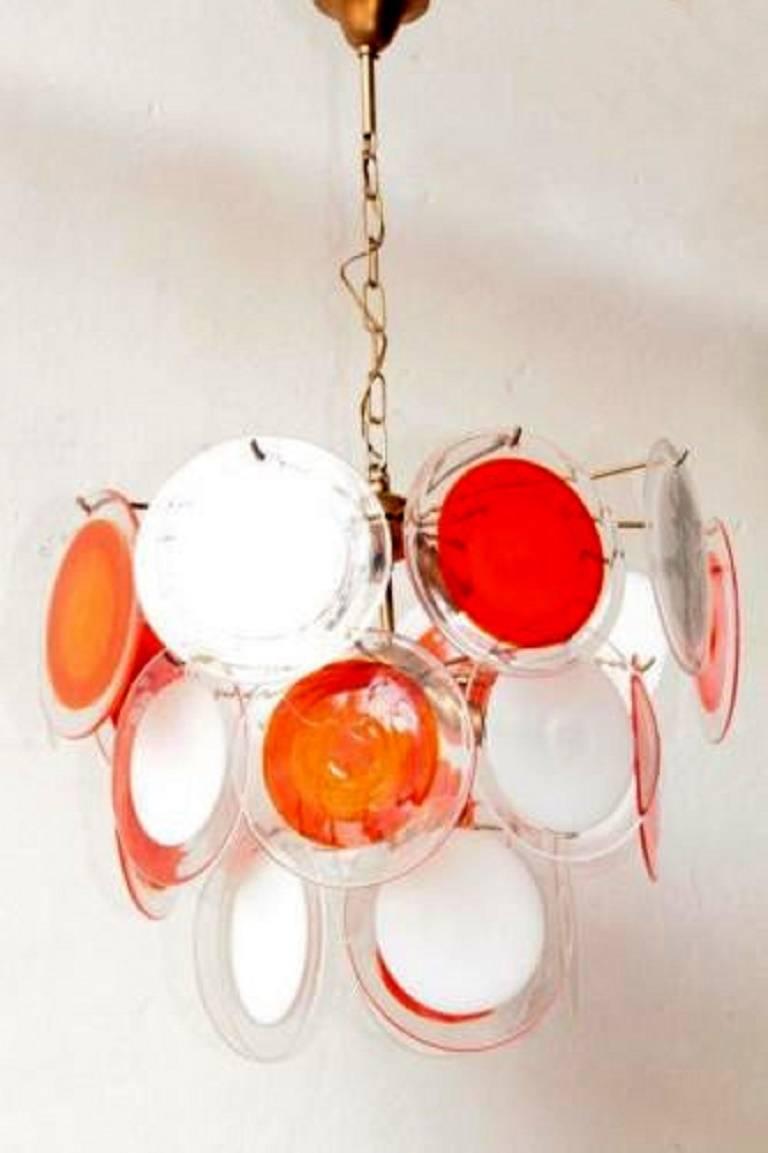 Gino Vistosi's fanciful chandeliers made in Italy during the 1960s are hard to find. This marvellous example features a variety of milk, tangerine, and clear handblown Murano glass discs.

Height includes chain and canopy.

A few general notes about