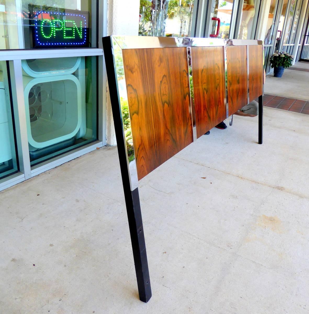 A king-size headboard with beautiful bookmatched rosewood veneers and chrome trim polished to a mirror finish. Holes for mounting to a standard frame (not included).

Pieces from this line are often attributed to Milo Baughman, but we cannot confirm