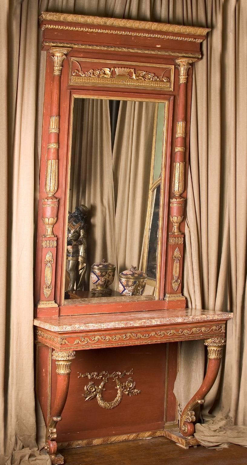 Colored brick red, this carved and gilded console and mirror set are a beautiful matching pair. The console is topped with a beautiful slab of brocatelle Violette d'Espagne marble, a marble with yellow ovals and runs of maroon throughout. The color