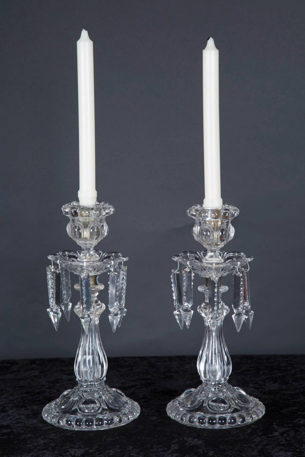 This pair of crystal lusters are made of beautiful St. Louis crystal, with a set of crystal prisms hanging down from the bobeche of each piece. A beautiful addition to any table top, watch the crystal sparkle in the candlelight in order to help set