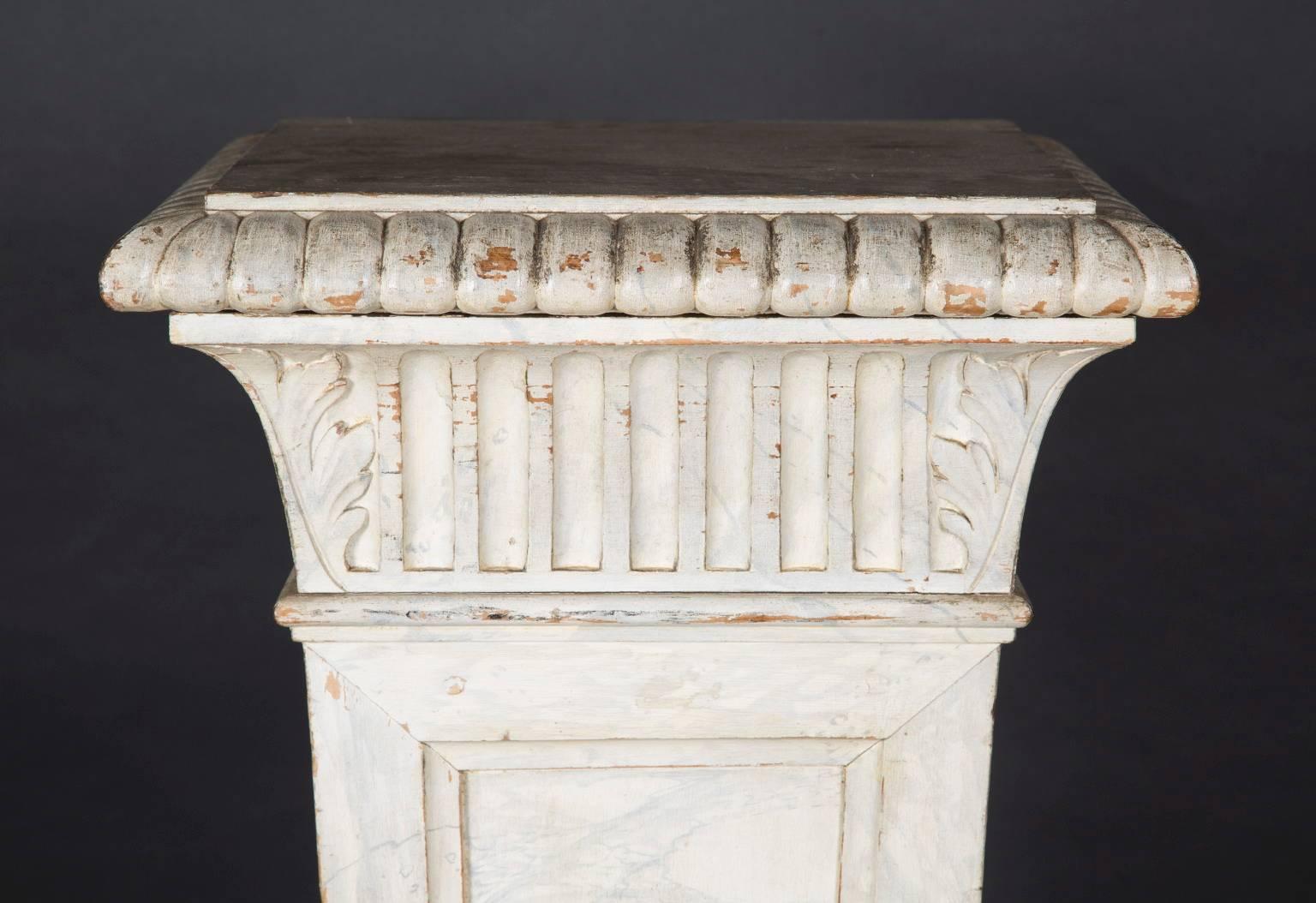 Ce grand piédestal a été fabriqué en France au XIXe siècle. Elle est faite de bois et est décorée et peinte pour ressembler à du marbre sur trois côtés. Le piédestal est orné de diverses sculptures, notamment d'une garniture sculptée en forme d'œuf