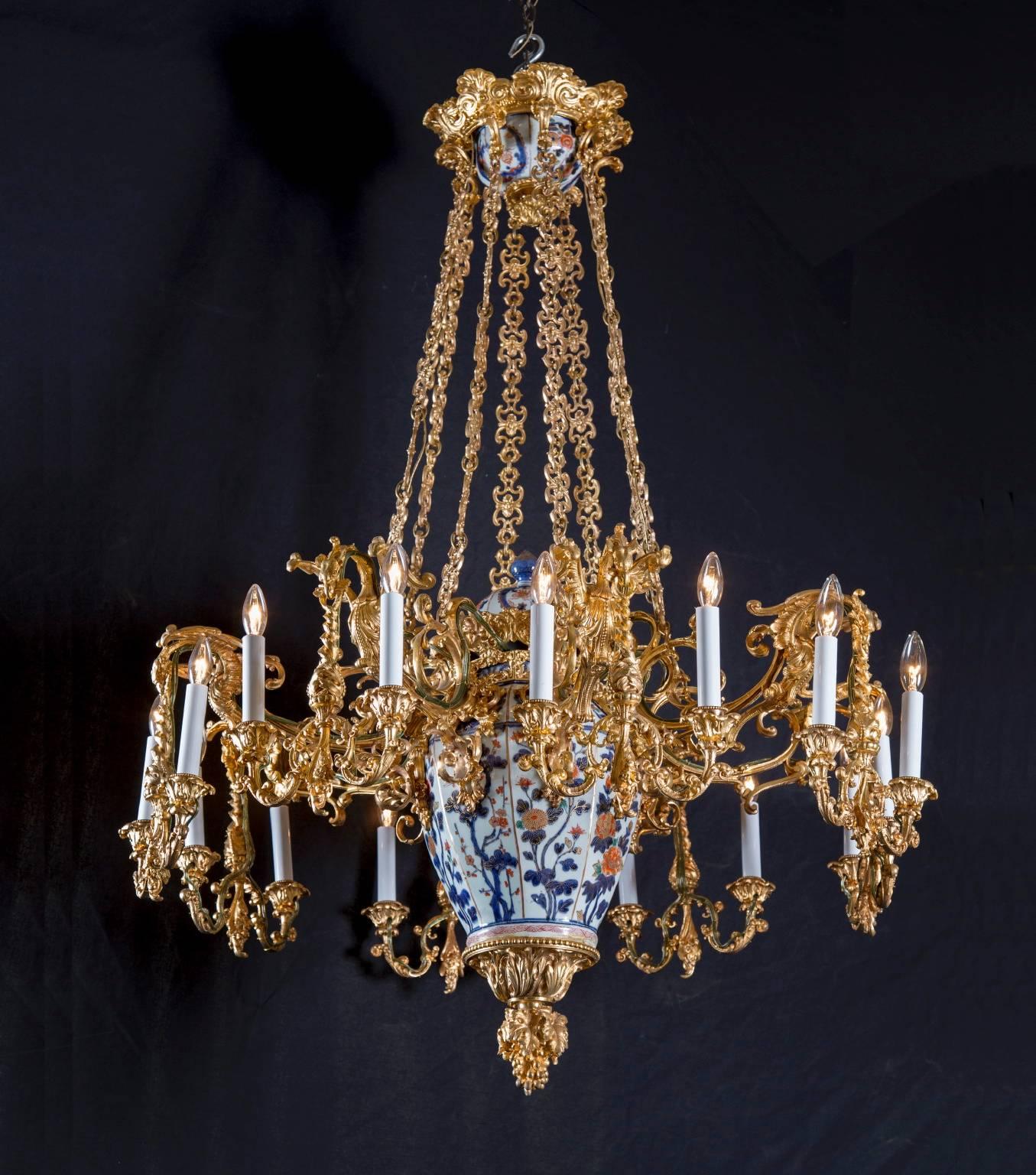 This unique chandelier is made from a fusion of antique Japanese Imari porcelain and French bronze and gold work. 19th century French craftsmen imported the Imari porcelain center, and then modified it by adding bronze arms and chains to turn the