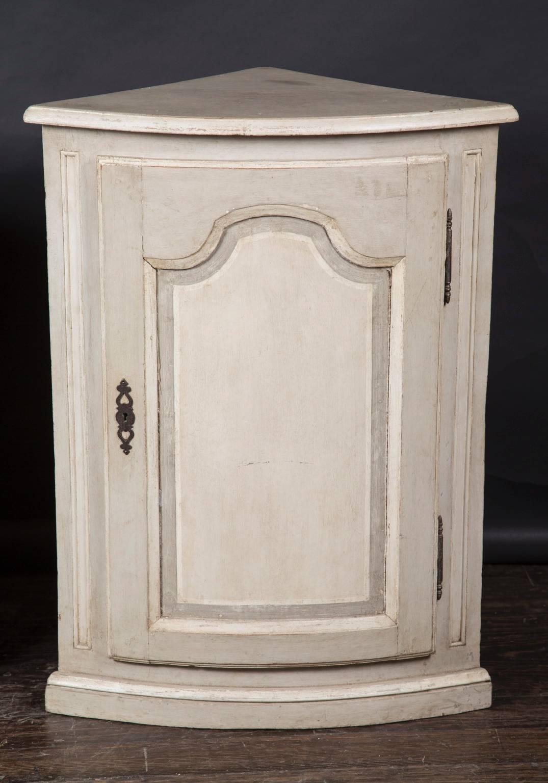 This antique pair of painted cabinets is designed to fit into the corners of a room, thus it's triangular shape. A perfect piece to add extra storage and counter space to a room.