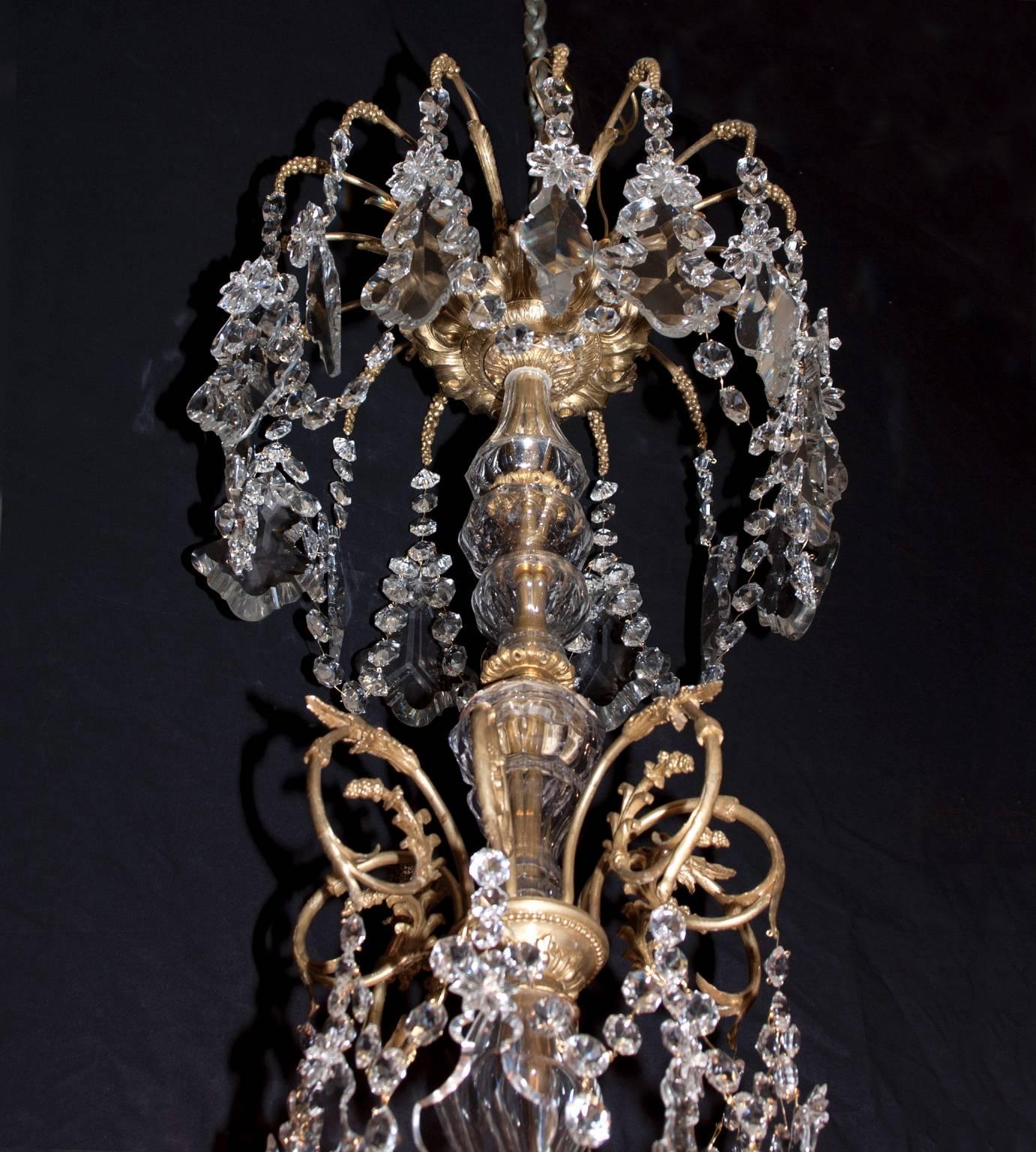 This antique chandelier hangs with quite the royal presence, an elegant figure and all Baccarat crystal. Forty-eight lights are staged in a three tier pattern. An elongated stem stretches upwards from the lighted tiers, ending in an elegant crown