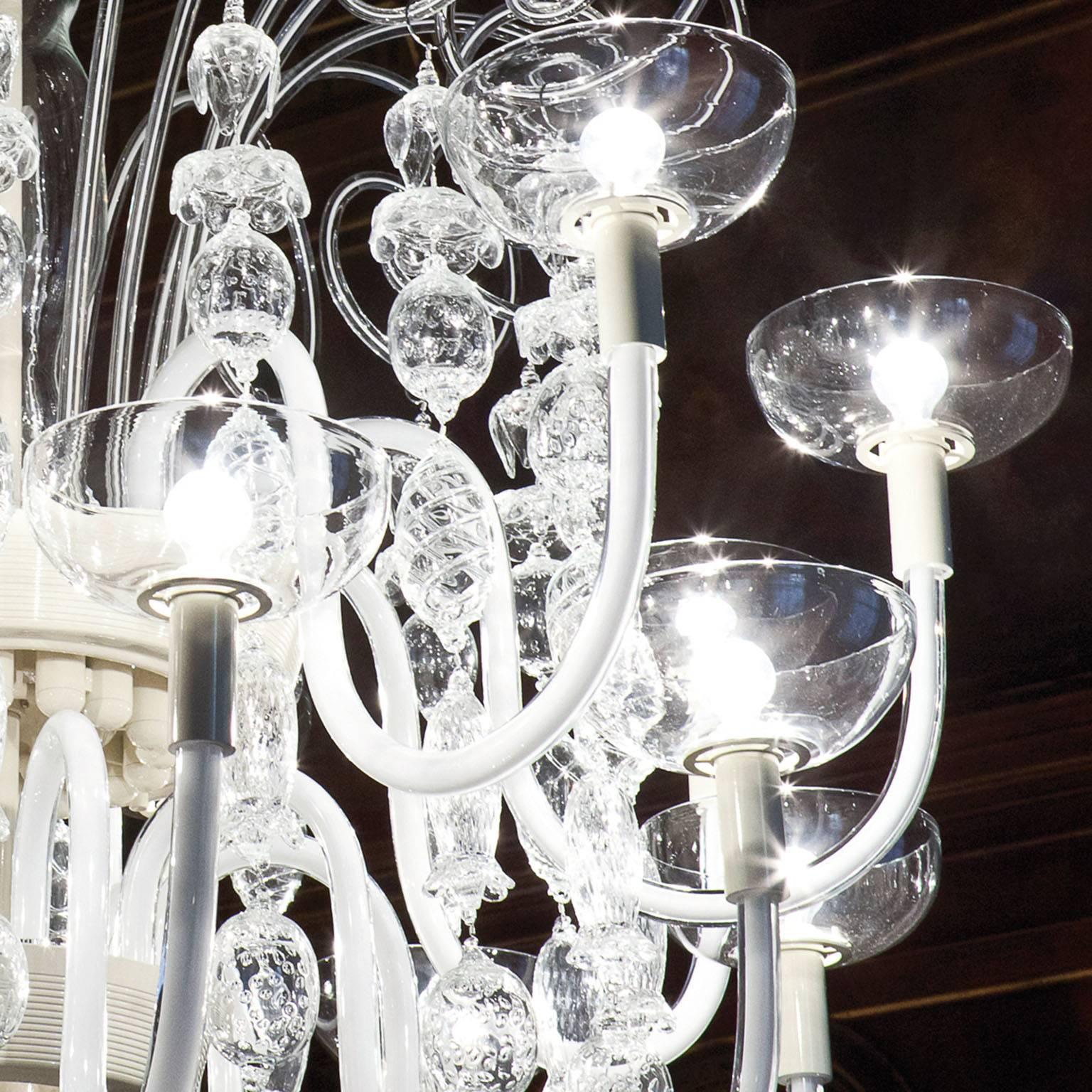 16 arms chandelier in handmade blown glass, crystal colored with milk white in the centre designed by Carlo Scarpa for Venini in 1940.
This is a re-edition limited in 19 artpieces blowed in 2013.
Metal: Ivory painted
Lighting source: 16 x max 60W