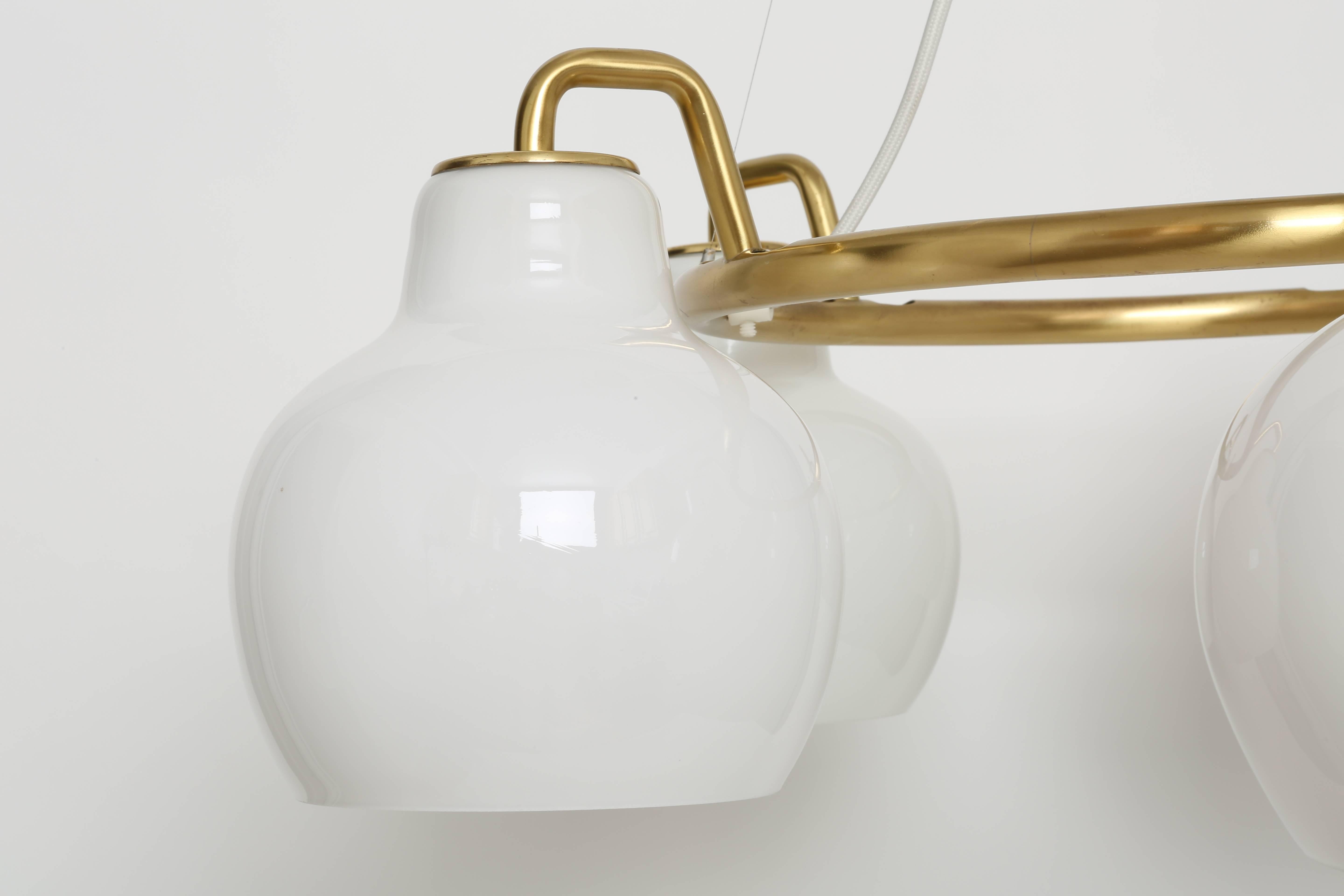 "Christiansborg" chandelier designed by Danish architect Vilhelm Lauritzen for Louis Poulsen.
Five handmade opaline glass bells and a solid brass ring.
Denmark, 1950s.
Two chandeliers are available.

Matching wall lamps are available
