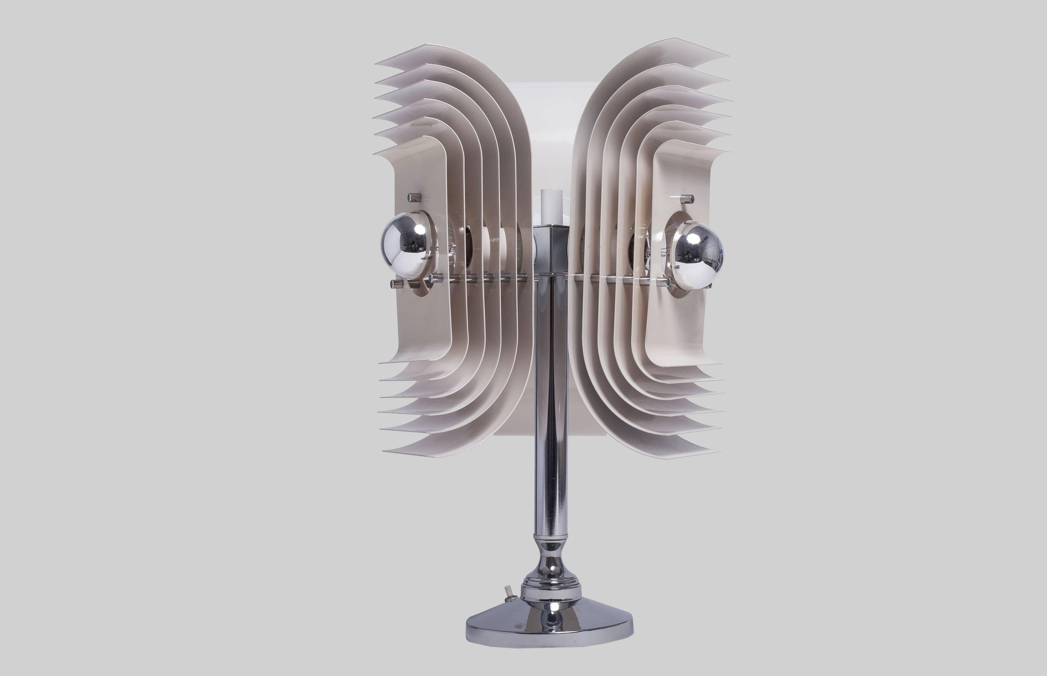 Italian table lamp in Stilnovo style.
Modernist and sculptural lamp to add an interesting twist to an interior.
Made with enameled metal and chrome-plated base.

  