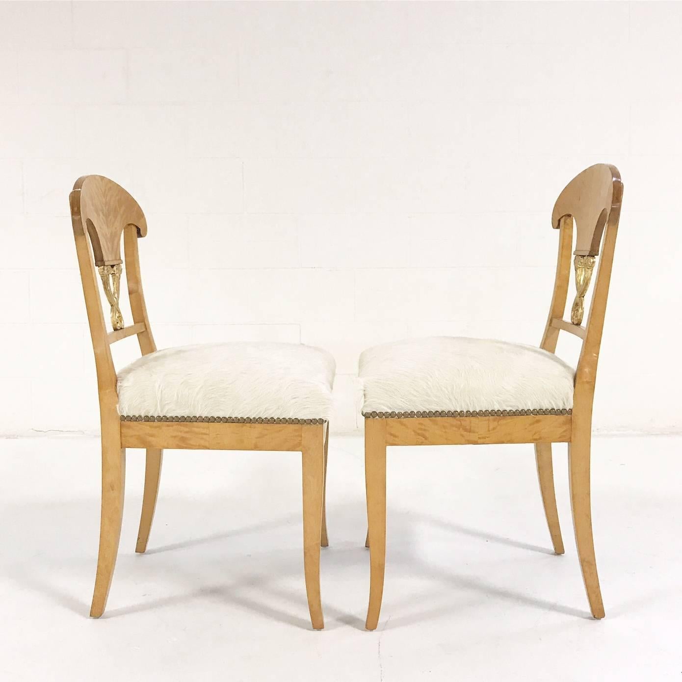 This is a lovely pair of Biedermeier chairs, circa 1820 Austria. We love the blond satin birch and the gilt details. We restored each chair with new foam and upholstered in our natural, silky soft ivory Brazilian cowhide.

Measure: 18