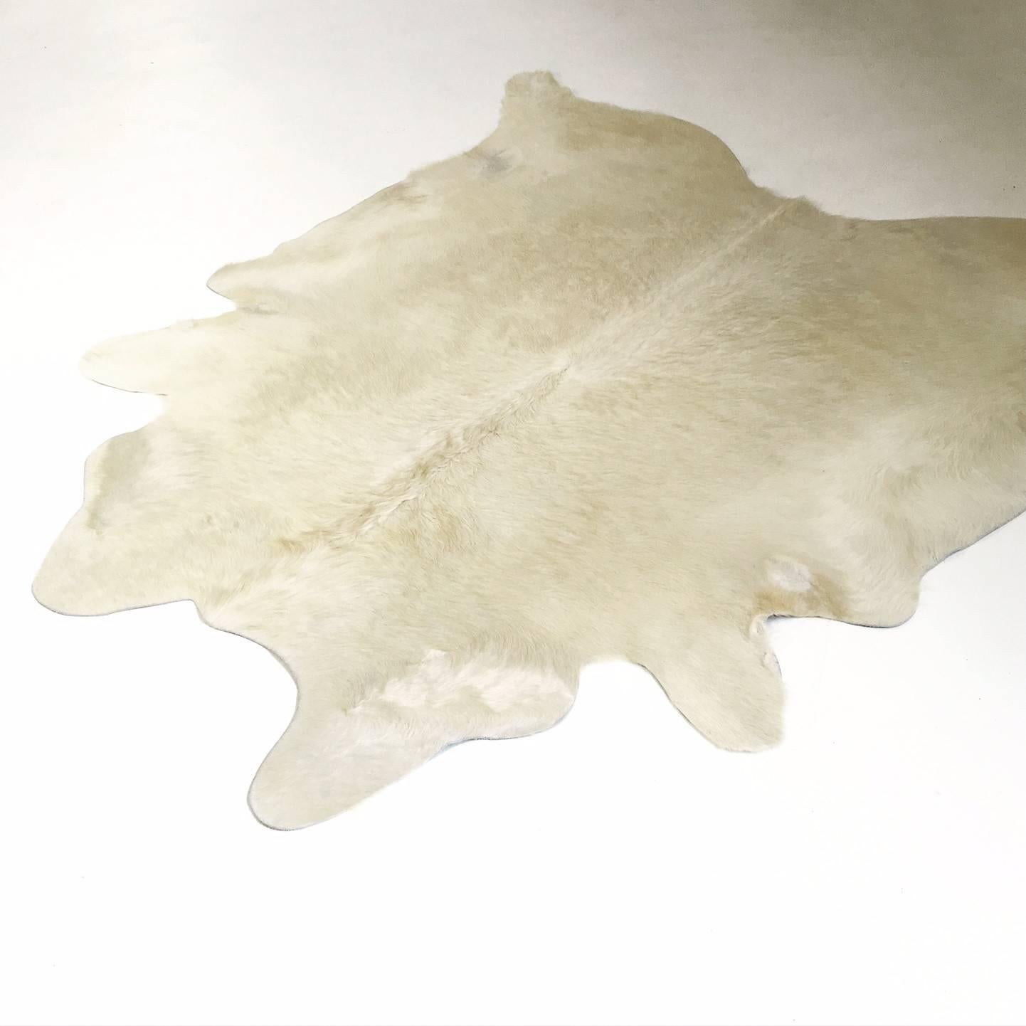 This hide is a natural ivory cowhide rug, a rare hide color. This rug has been hand-selected by our critical-eyed Forsyth team and meets our high standards of hair quality, coloring, tanning excellence and size. You will not find a cowhide rug as