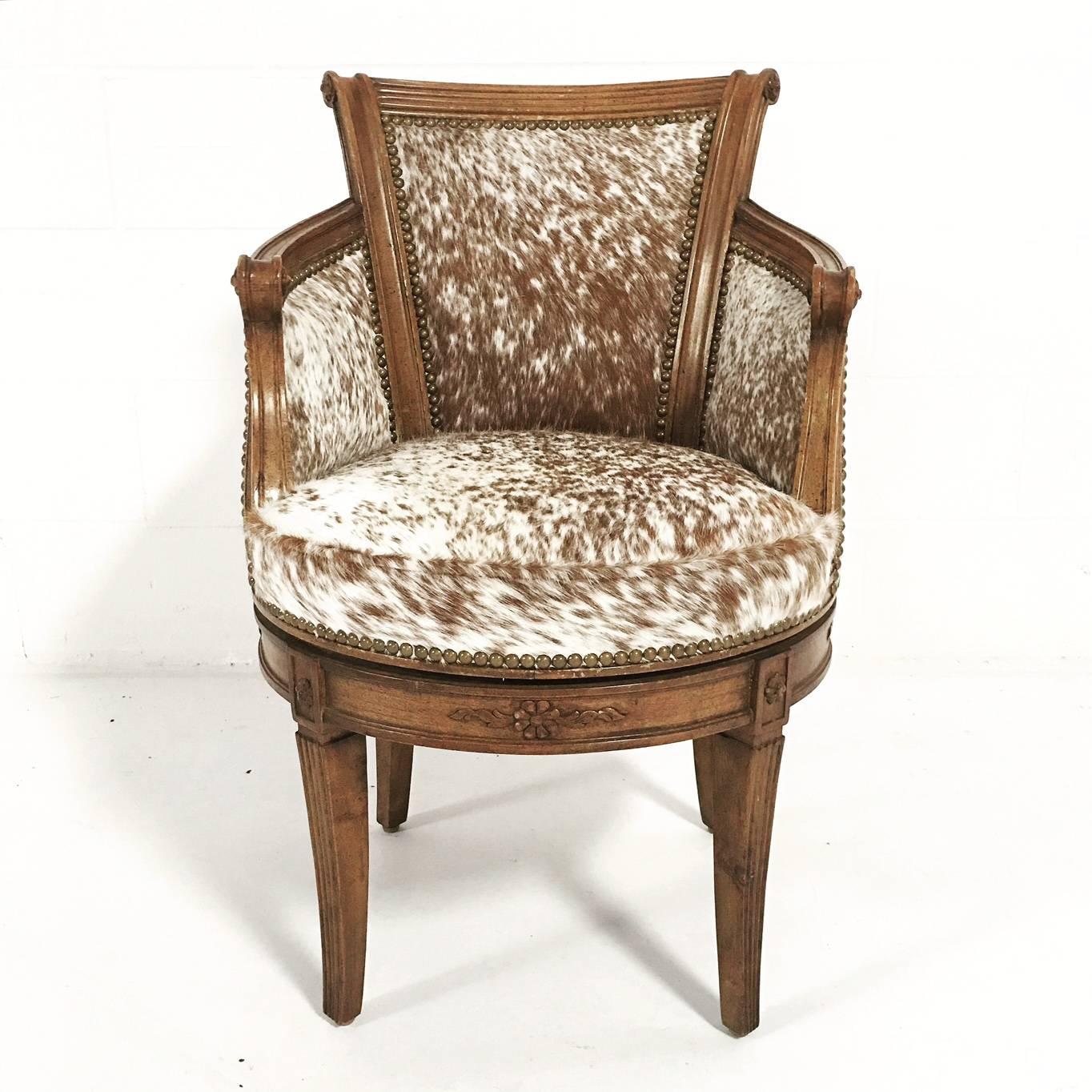 Adorable, vintage swivel chair. Beautifully reupholstered in our brown and white speckled cowhide and finished with brass nailheads.

 Measures:

Length: 20 inches.

Depth: 16 inches.

Back height: 32 inches.

Seat height: 17.5 inches.
