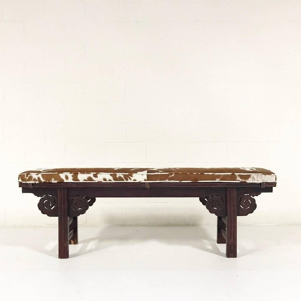 We love the richness of the reddish-brown mahogany colored cowhide with the red-toned wood of this beautiful bench. Nearly 90 years old from the Tientsin Province of China, this bench is perfect for a kitchen table as it is carved on both