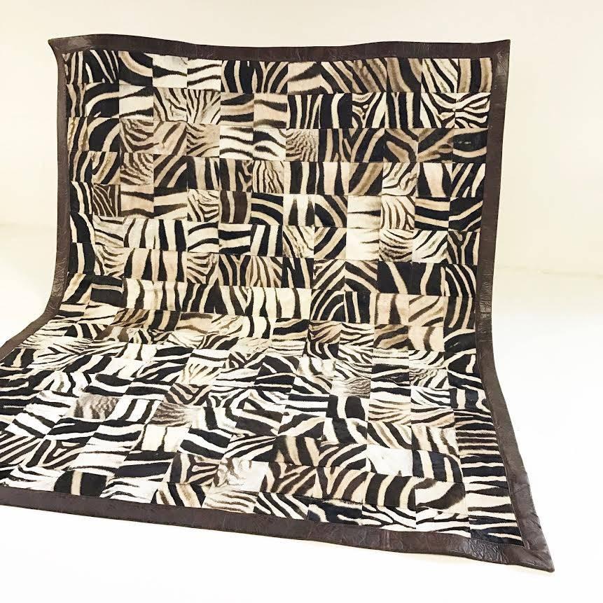 We put our expert upholstery team to the test on this one of a kind rug. Over the course of a few labour-intensive months, 221 individual zebra hide squares approximately 6.5 inches each were hand-cut, hand-stitched, and patterned to create this