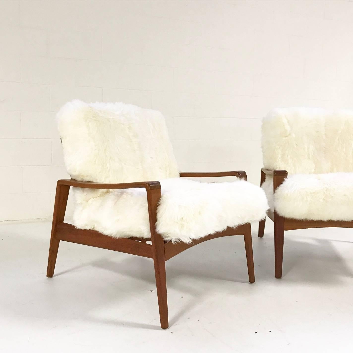 This is a beautiful pair of teak Danish lounge chairs designed by Arne Wahl Iversen for Komfort. Made in Denmark and manufactured in 1960. Our Forsyth design team chose our luxurious New Zealand sheepskin for the cushion upholstery. Like sitting on