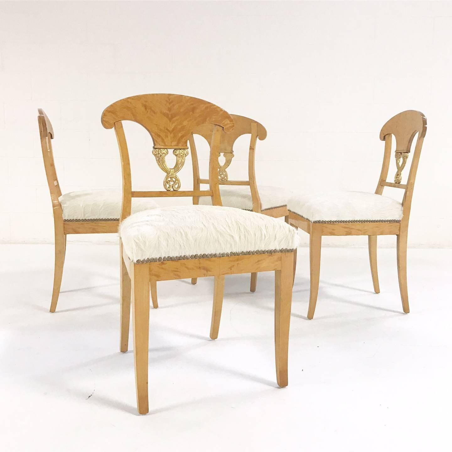 This is a lovely set of four Biedermeier chairs, circa 1820 Austria. We love the blond satin birch and the gilt details. We restored each chair with new foam and upholstered in our natural, silky soft ivory Brazilian cowhide.

Measure: 18