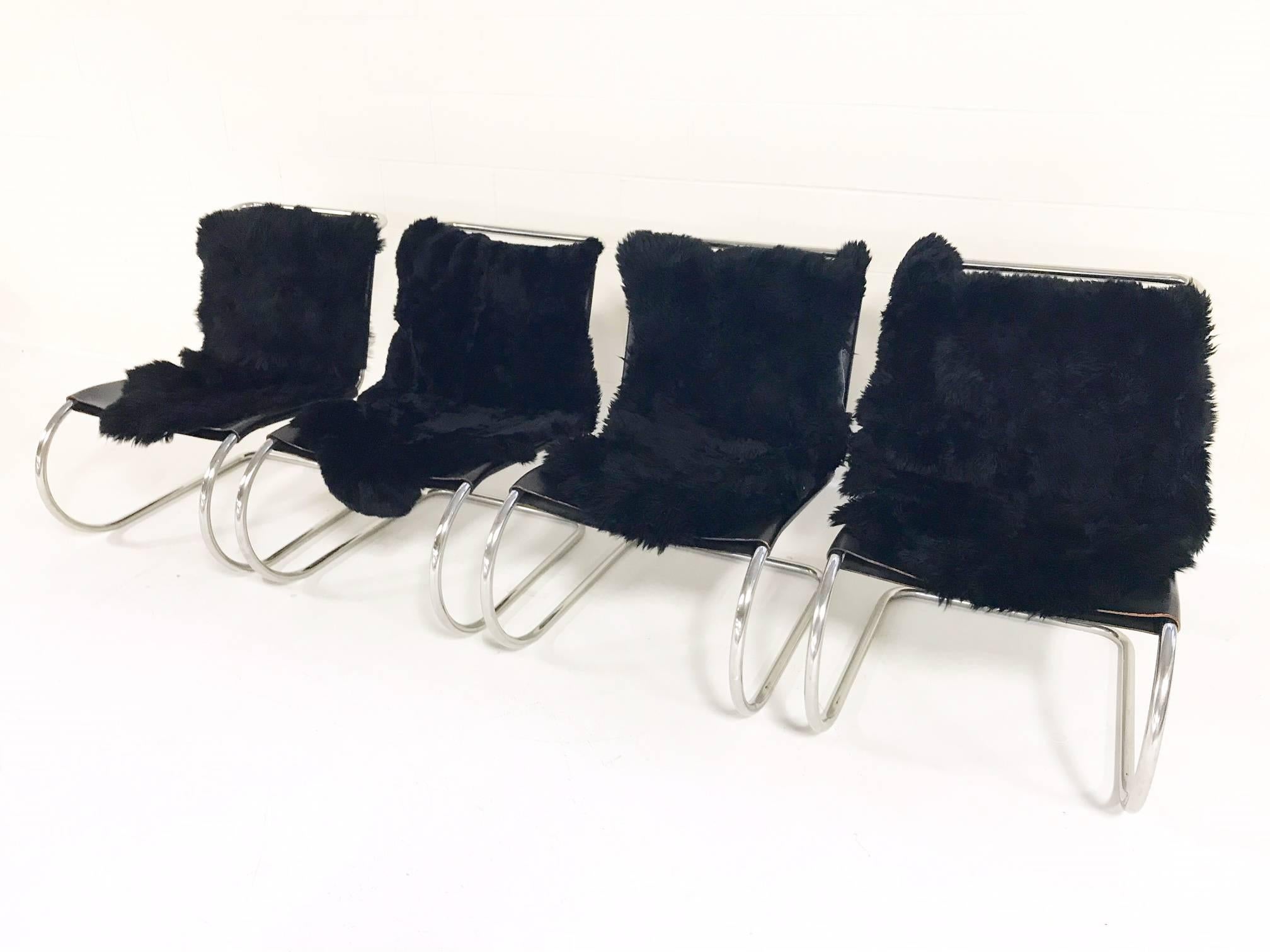What an icon! The MR chair designed by Mies Van Der Rohe is an instantly recognizable design. We collected this group of four MR Chairs at auction. They are in excellent vintage condition. We added four cozy, rustic black Brazilian sheepskins for a