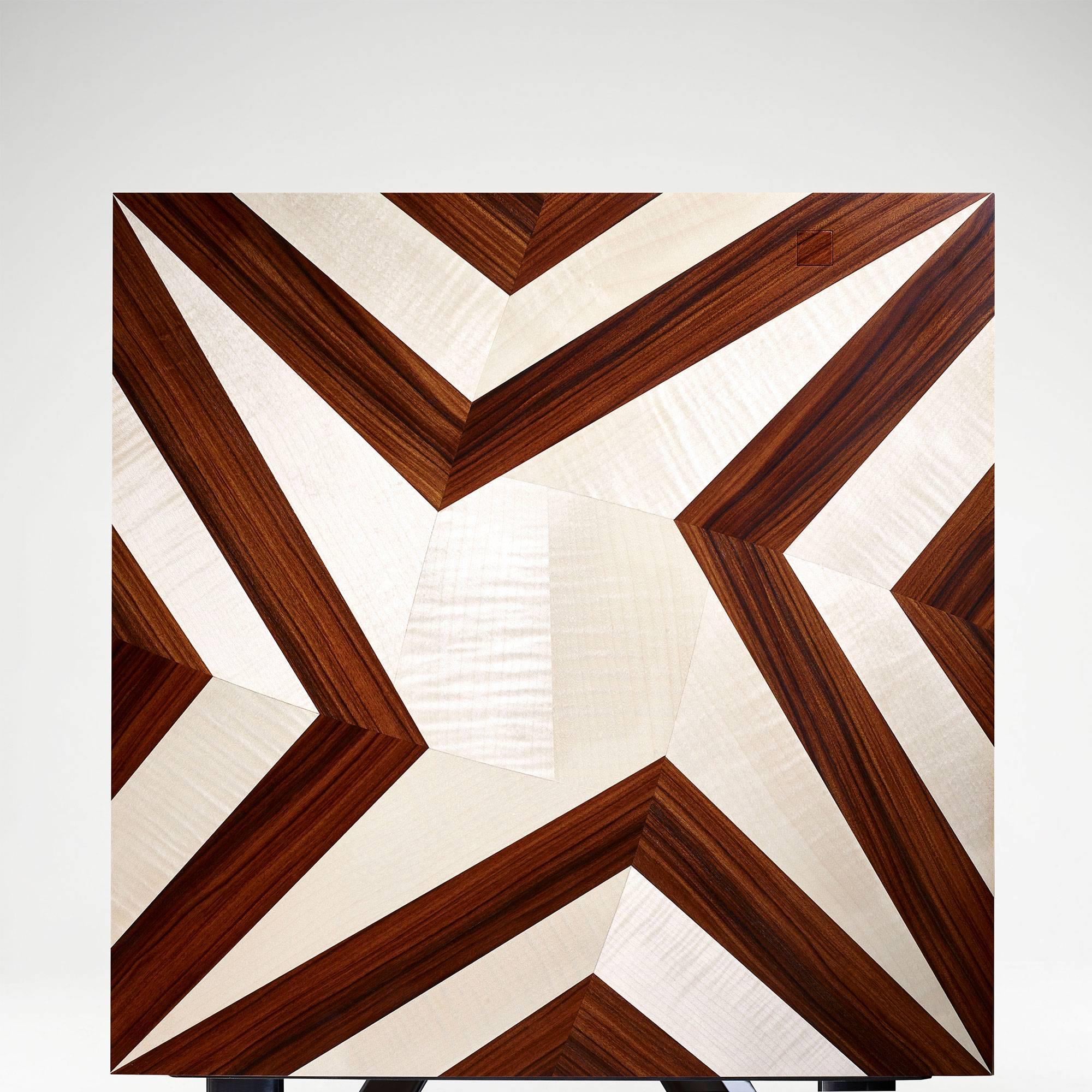 The Vortex Cabinet is as much a work of art and a puzzle as it is an item of furniture. Covered in a veneer of Sycamore and Santos rosewood, the marquetry design challenges the perceptions of a usual cabinet. An optical illusion with seemingly no