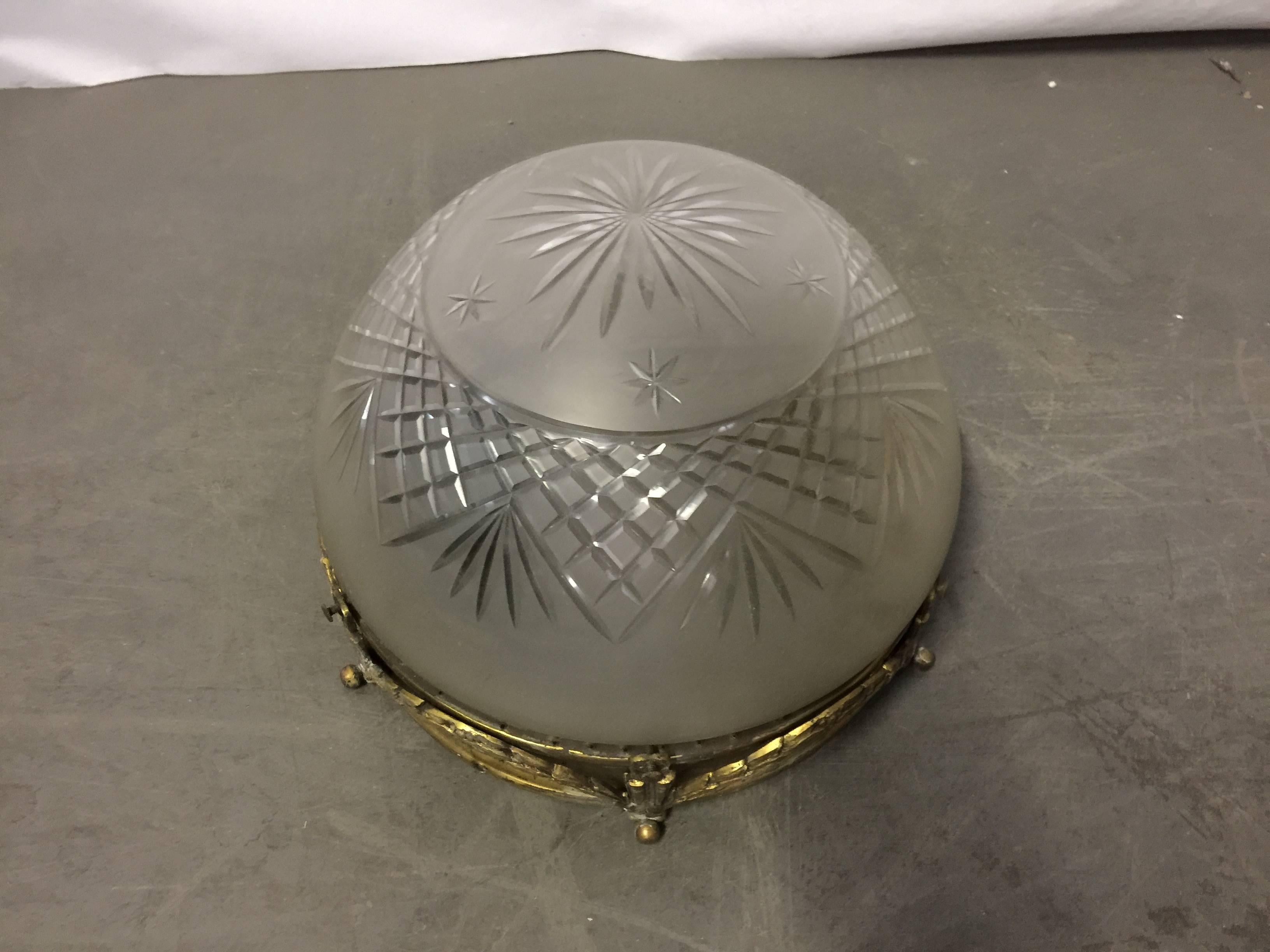 Plafonnier vers 1900, en métal doré et verre gravé.