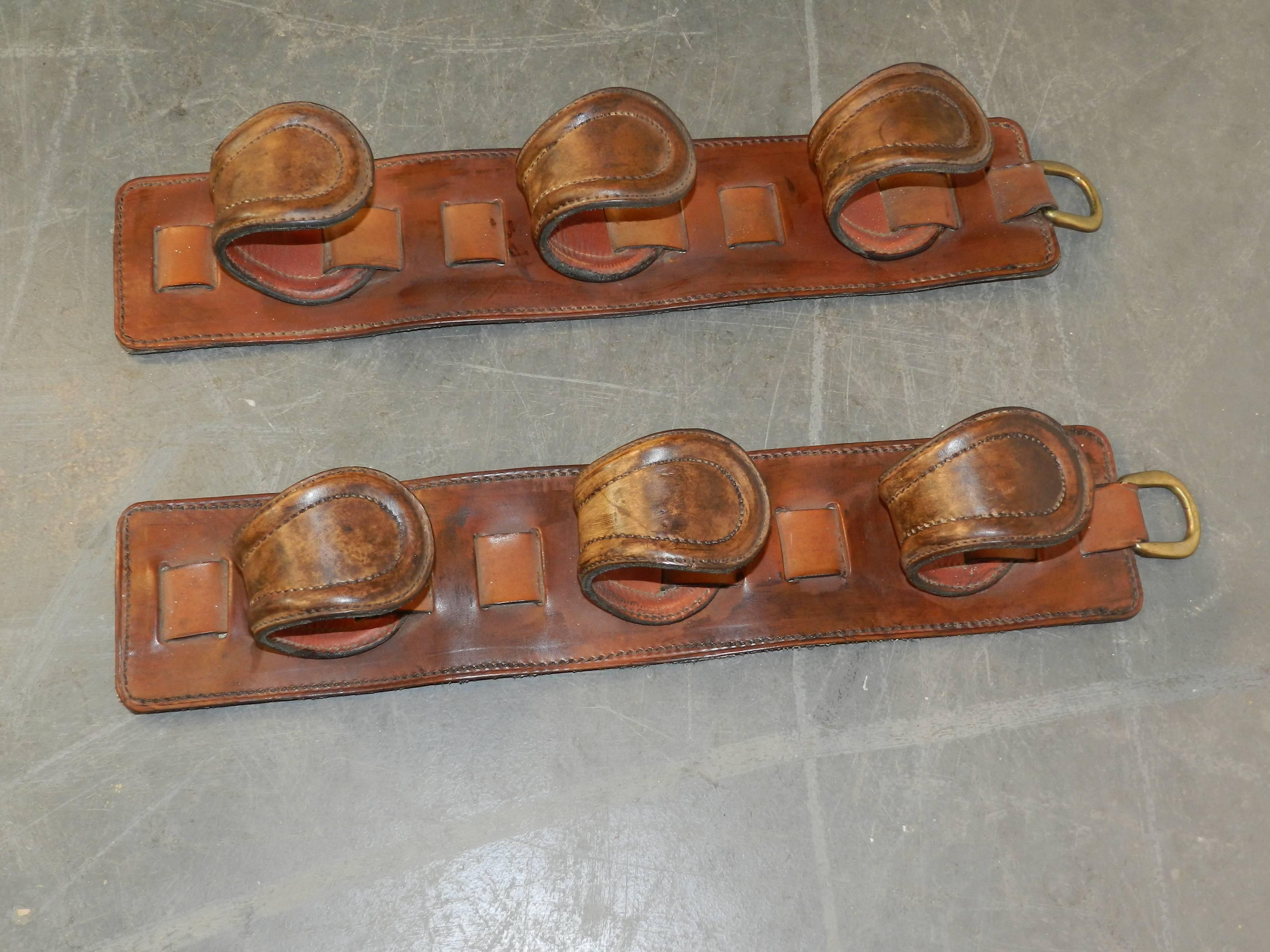 Pair of gun racks in leather in the style of Jacques Adnet, circa 1950.