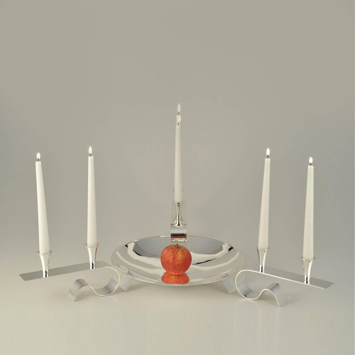 Centerpiece with an elegant central vessel for fruits or finger food and three two-flame candle holders. The vessel is handmade and three cuts create the three legs that support it. The exquisite candle-holders are flame-glazed by hand. The metal is