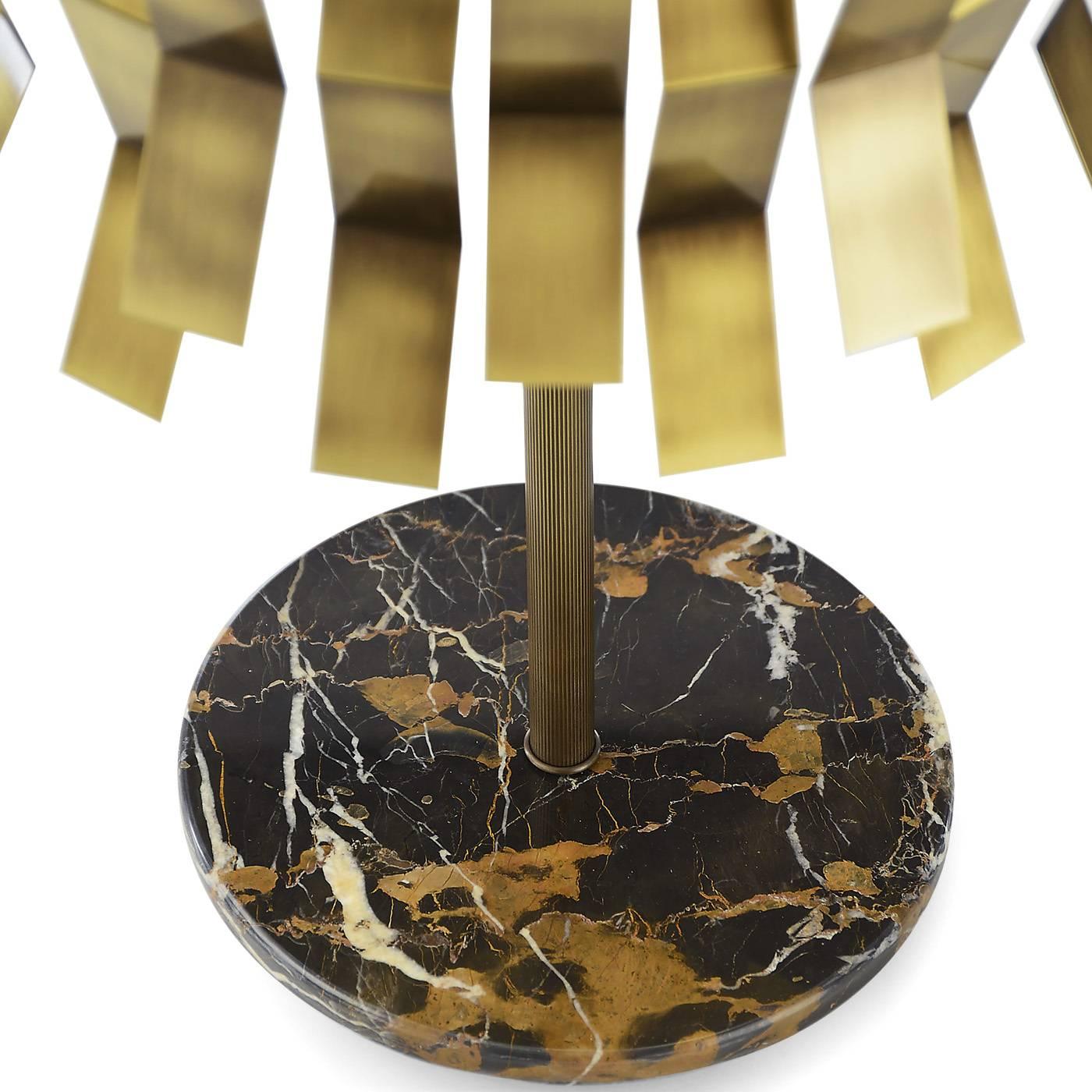 This striking brass sconce, designed by Studio 63 for Marioni, is decorated with geometrical metal accents that run all around its round perimeter and LED strip lighting. The base is an exquisite Saint Laurent marble ring.