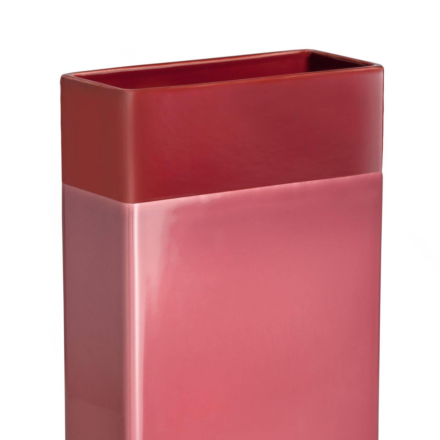 This striking vase has a simple, rectangular shape, highlighted with a brass strip at the bottom and two different solid finishes, one large strip in pink and a vivid red top. The piece in white clay was designed in 2016 by Dimore Studio for Bitossi.