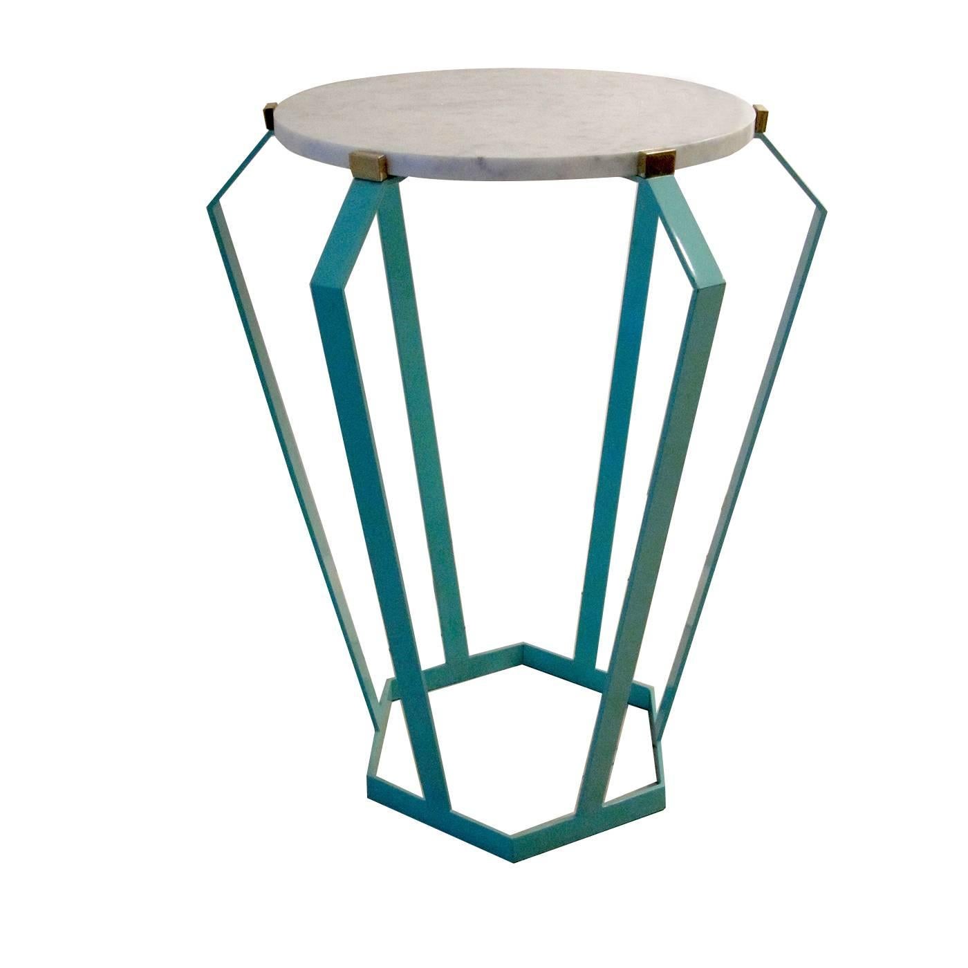 This striking coffee table has an hexagonal base in iron with a pale blue finish. Brass accents connect the support to the round top in fine Carrara marble. 