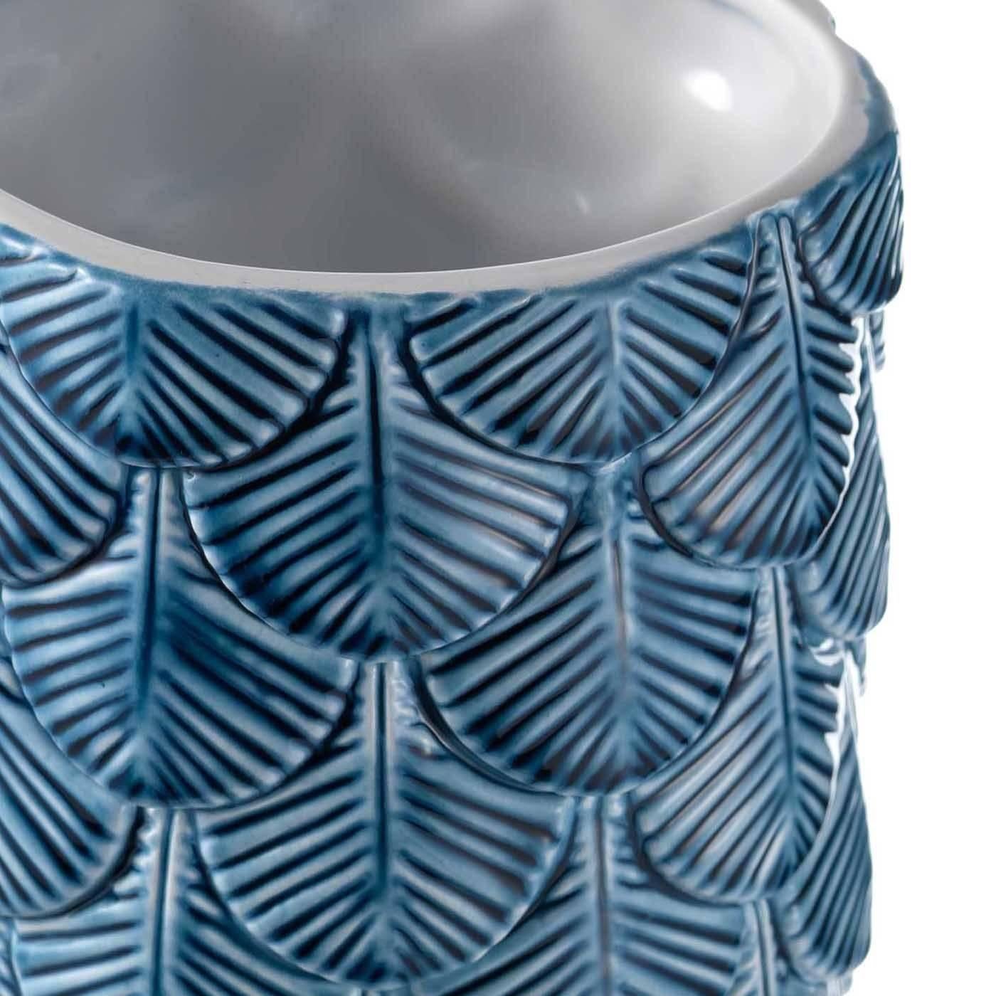 In this striking vase, the rows of exquisite ceramic feathers that run all around its cylinder have a blue enamel finish at the top that gradually fades into white. Each feather was decorated by hand by expert artisans for a sophisticated finished