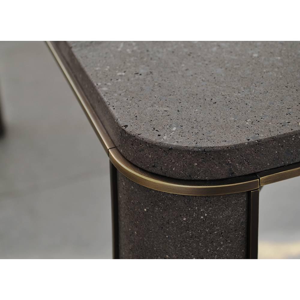 The timeless allure of this table comes from the use of a Classic material such as basaltina marble to cover a contemporary material such as the steel of the structure and its wide four legs that feature with a brass finish. The Minimalist
