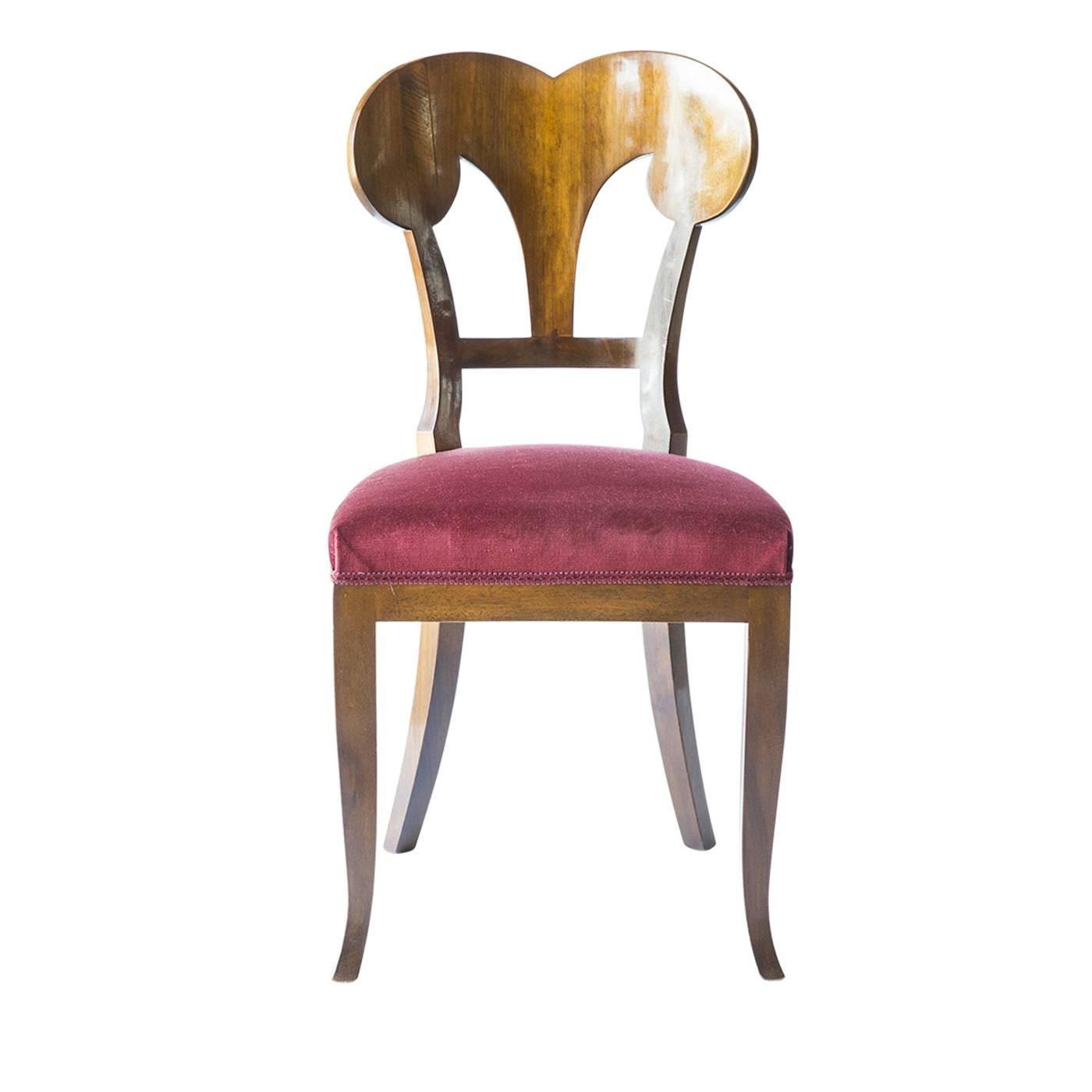 Set of four dignified Biedermeier seats executed with a wine-colored velvet tapestry for the seat. The structure is in solid walnut wood, while the color of the veneering is in a medium shade of walnut. The foam rubber padding is in non-deformable
