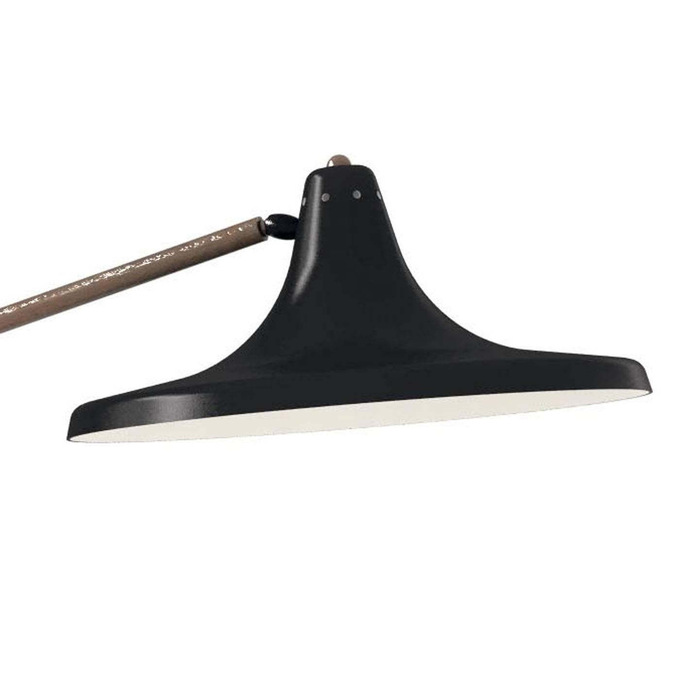 A modern interpretation of the iconic gooseneck lamp, this desk lamp features a round base and shade in metal with a glossy black finish. The shaft, curved to accommodate the large opening of the shade, is in brass with an elegant bronze finish that