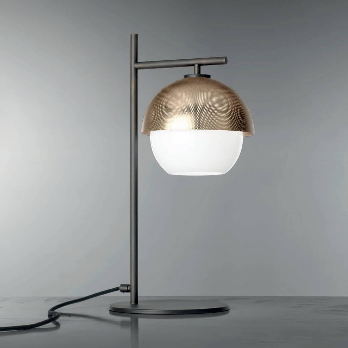 This elegant table lamp is an exquisite balance of straight and round lines. The spherical white Murano mouth-blown glass diffuser screens the light making it soft and relaxing. The semi-spherical metal shade can have a matte black or a matte golden