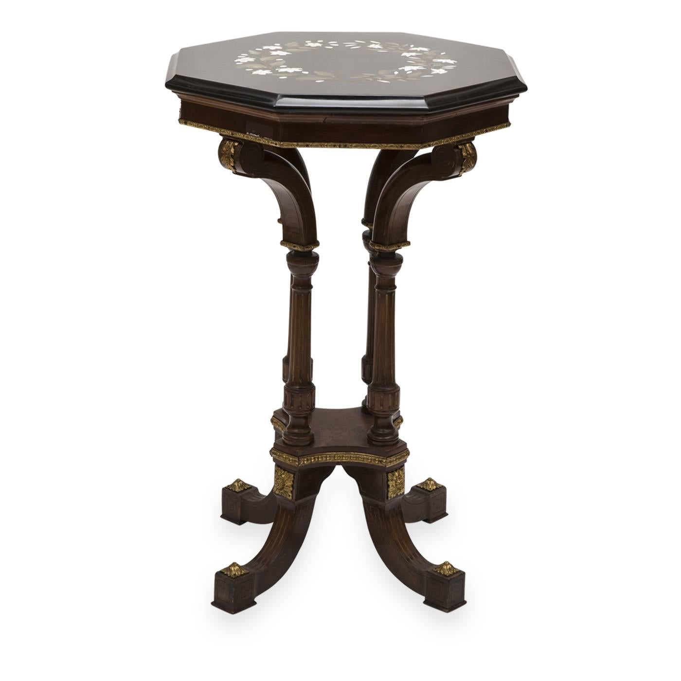 This is a florentine mosaic table in striking black Belgian marble by Traversari Mosaici. This luxurious piece is decorated with a pure white fleur-de-lis garland that evokes a regal presence. The hand-carved wooden table supporting the marble slab