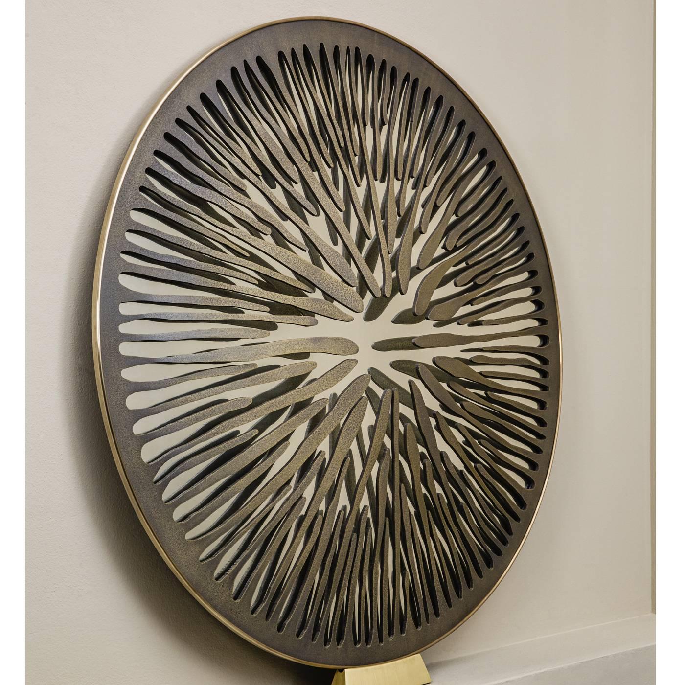 One of only two existing copies of its kind, this elegant sculptural mirror is meant to represent the pupil of an eye and its uniqueness is signed and certified by the artist. The structure of the piece is in brass coated aluminium with a worm