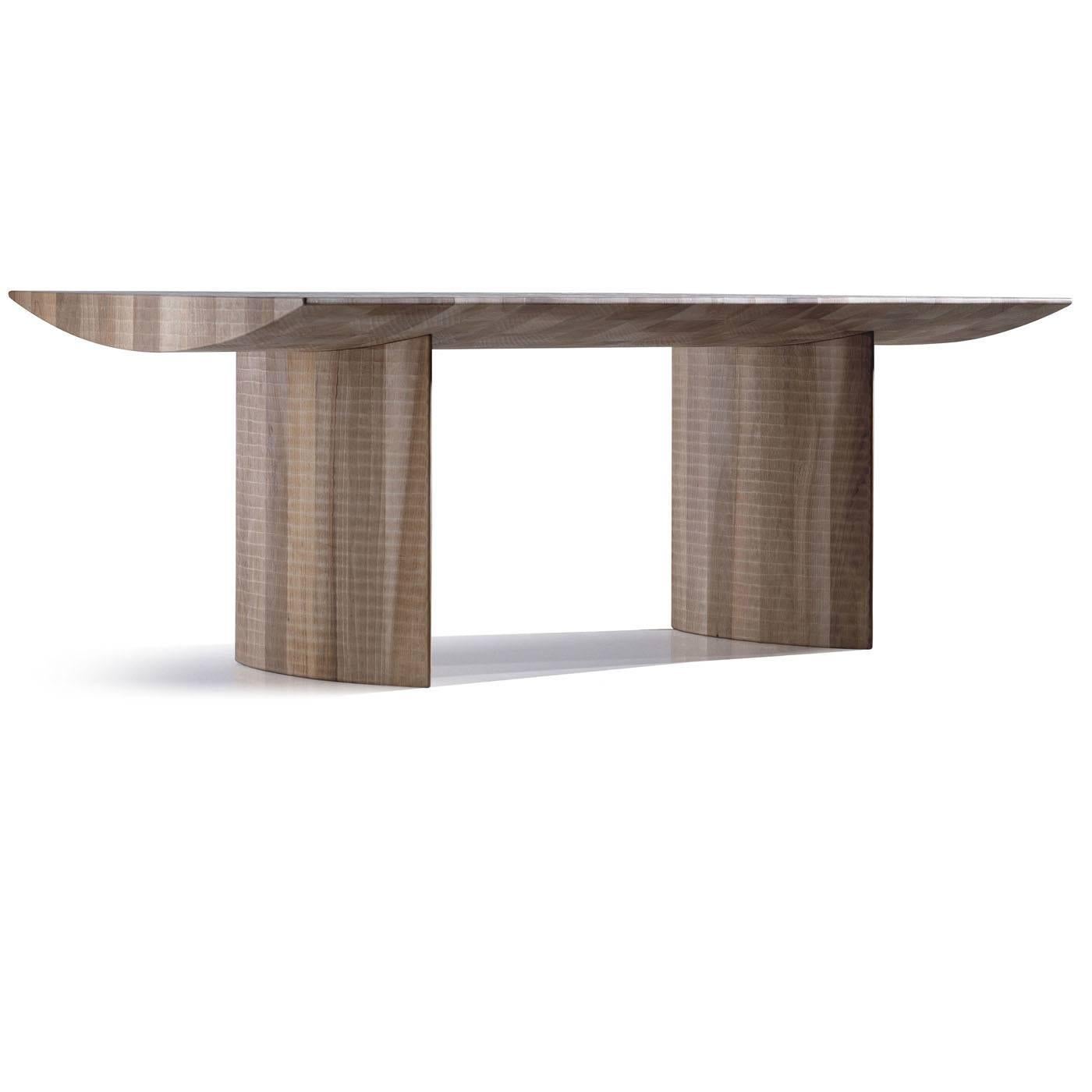 The solid Italian walnut wood of this imposing table is hand worked with a raw edge. The result is a minimalist object made of three lines that evoke both the density and the substance of the matter they are made of.