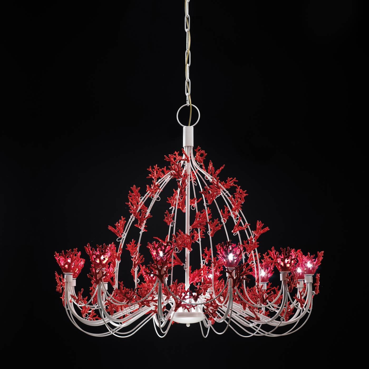 This elegant chandelier is a true objet d'art. This piece features 12 skyward curving arms stemming from a central structure in polished opaque white metal. The entire framework and arms are adorned with completely handcrafted red ceramic coral