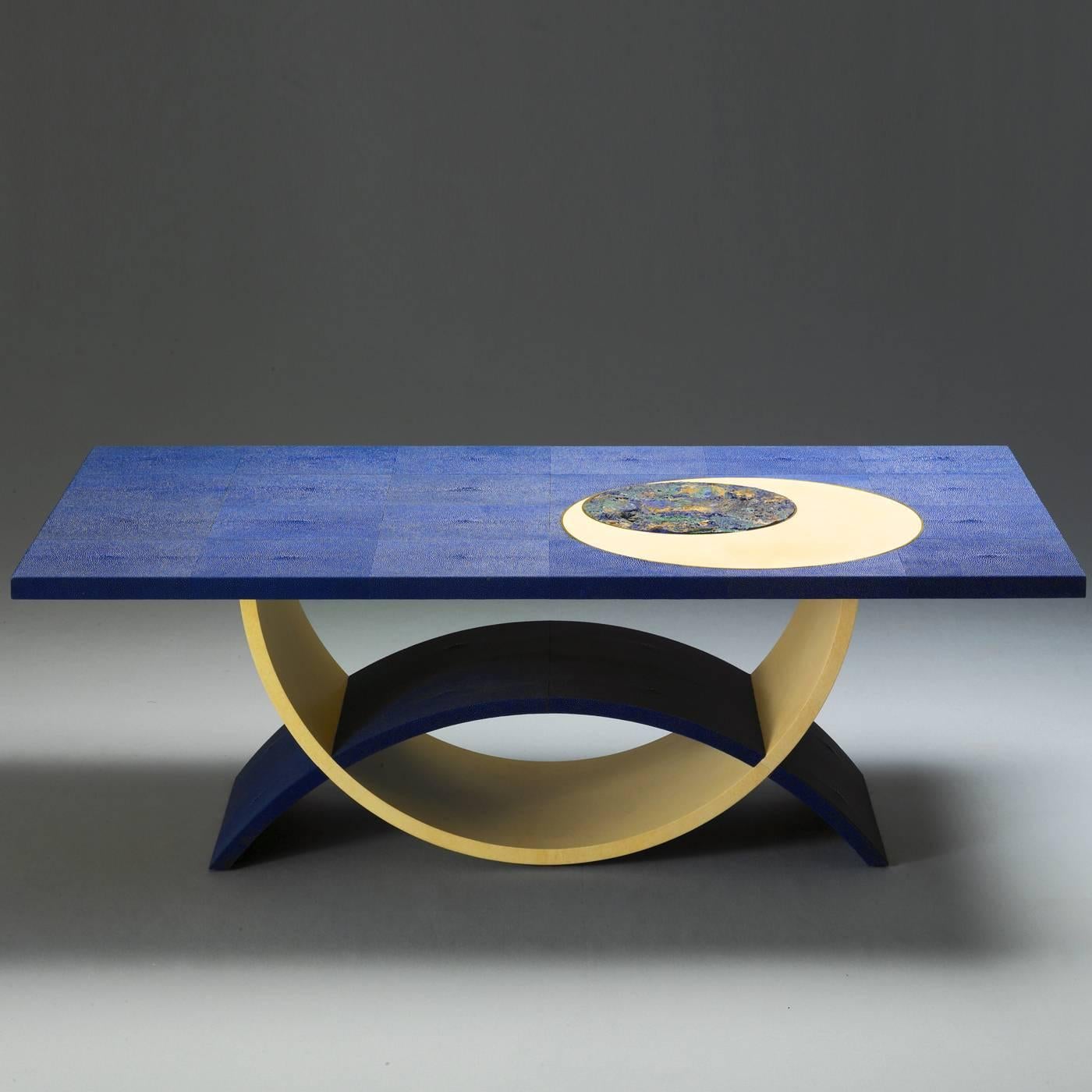 Cette table de salon saisissante présente un plateau garni de galuchat bleu (avec sa texture rugueuse caractéristique). Le sommet est orné d'un insert rond en pierre azurite à l'intérieur d'un plus grand rond en parchemin dont le profil extérieur