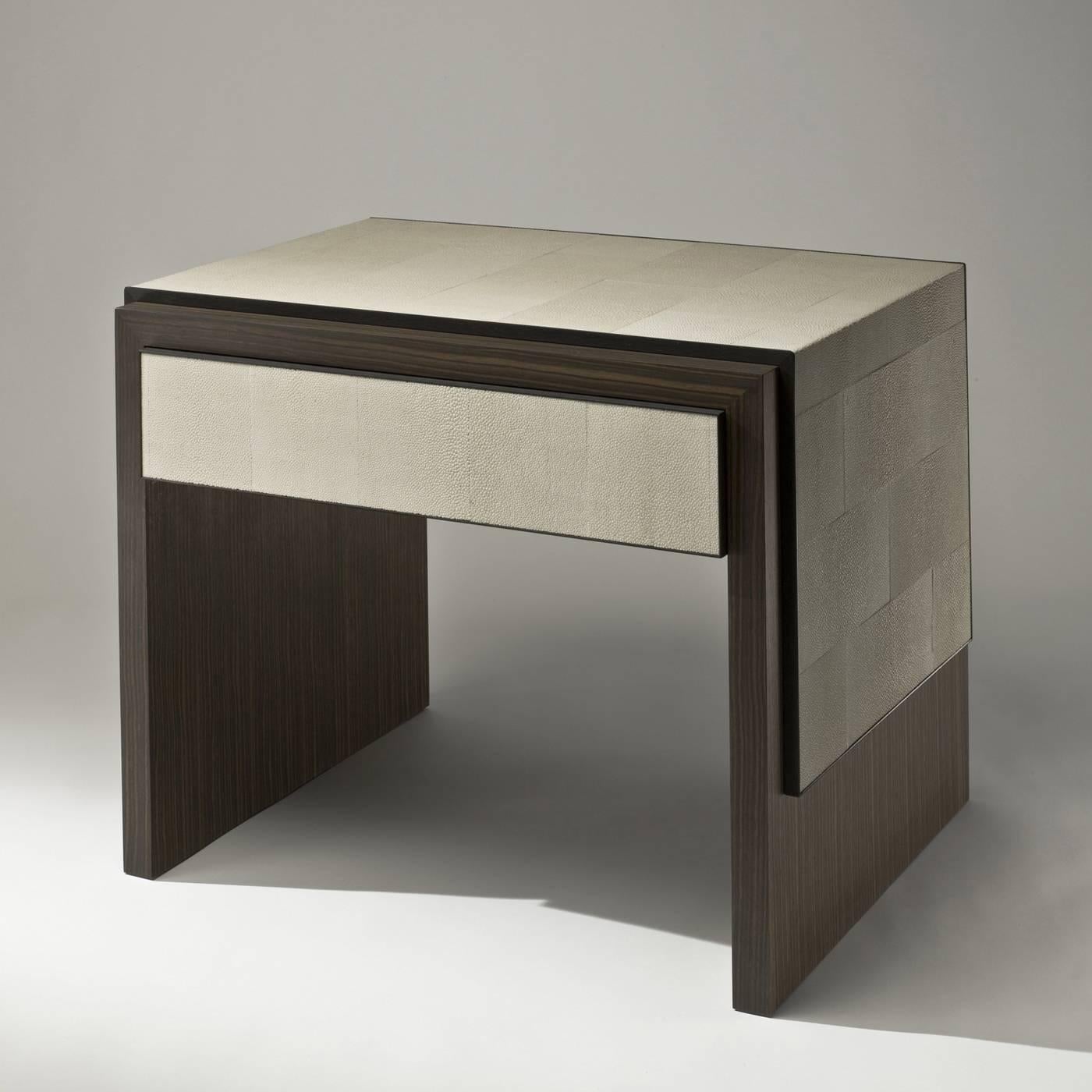 This table is in ebony Macassar wood, with its distinctive dark brown stripes. It features accents in beige shagreen around the top and sides and on the front of its single drawer. The interior of the drawer is in maple wood.