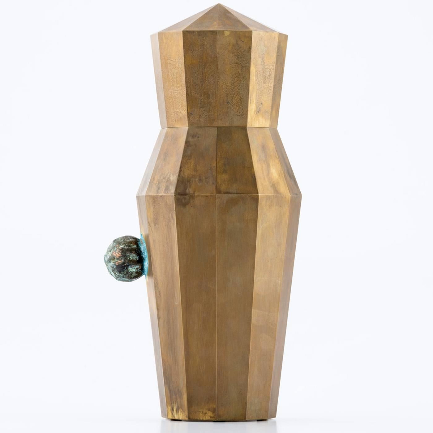 This exquisite vase is crafted using a technique where a CNC cutting machine is used to shape brass plates which have been oxidized by hand. This technique allows for the creation of sharp and precise bends and edges. This vase also features a