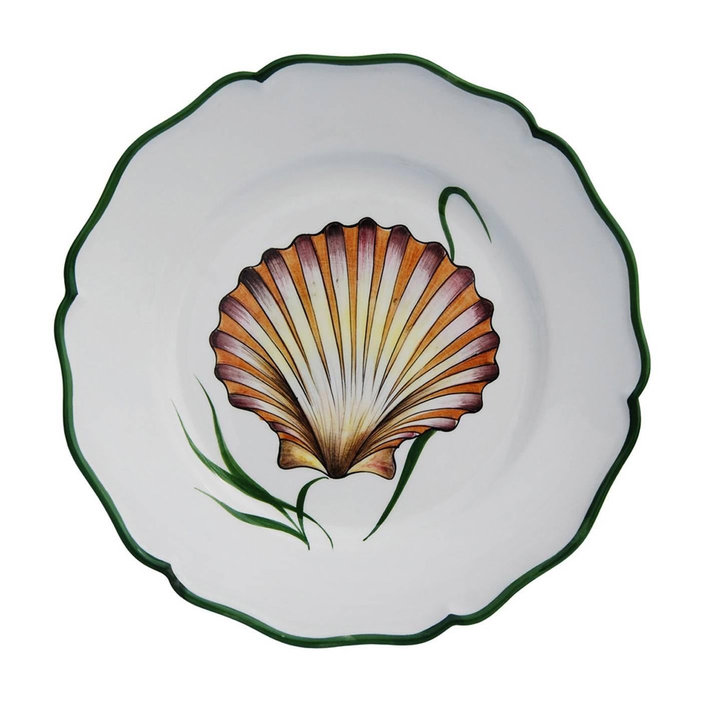 Decorative shell motifs on an elegant white background are set against a dark green rim in this set of four ceramic plates entirely handcrafted and hand-painted by expert artisans in the Northern-Italy town of Este. This set matches other sea-life