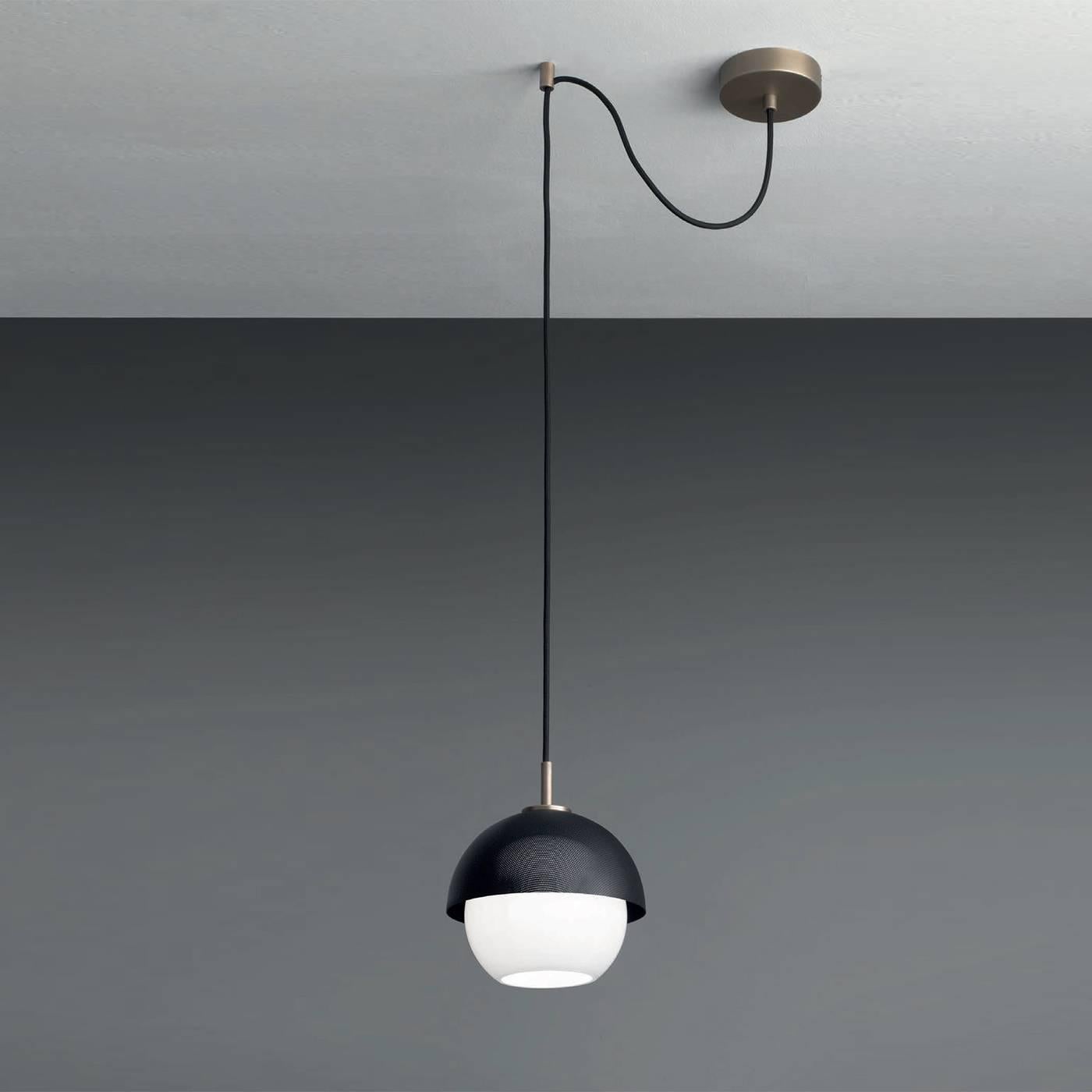 Questa elegante lampada utilizza un design moderno e materiali tradizionali per trasmettere una raffinatezza senza tempo. La sua struttura, che può essere regolata, è in ottone con finitura brunita chiara o scura, mentre il paralume semisferico è in