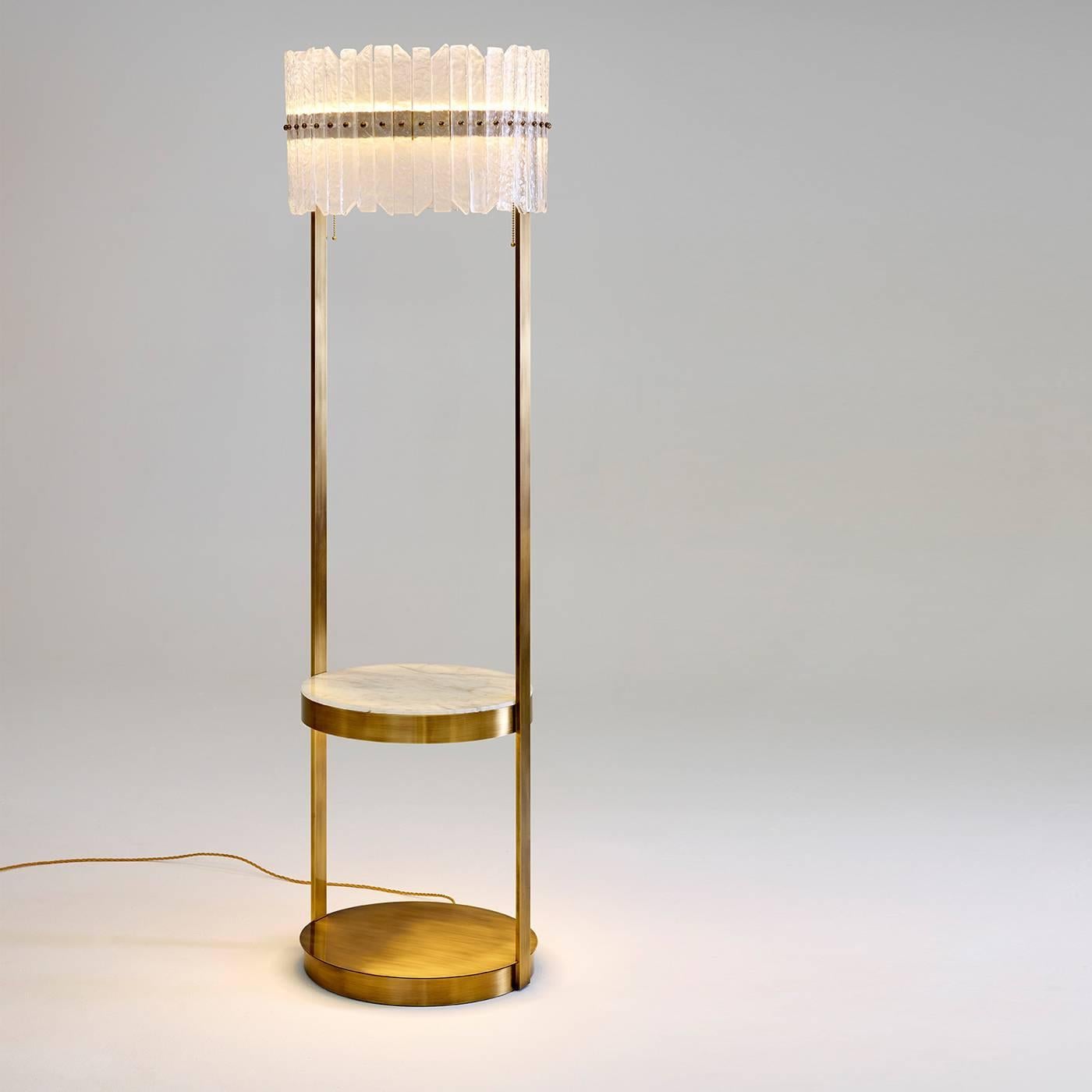 Golden brass uplighter designed by Studio 63 for Marioni. The piece features a small table in the middle and support at the base, both circular, as well as a back-lighting and decorative glass.