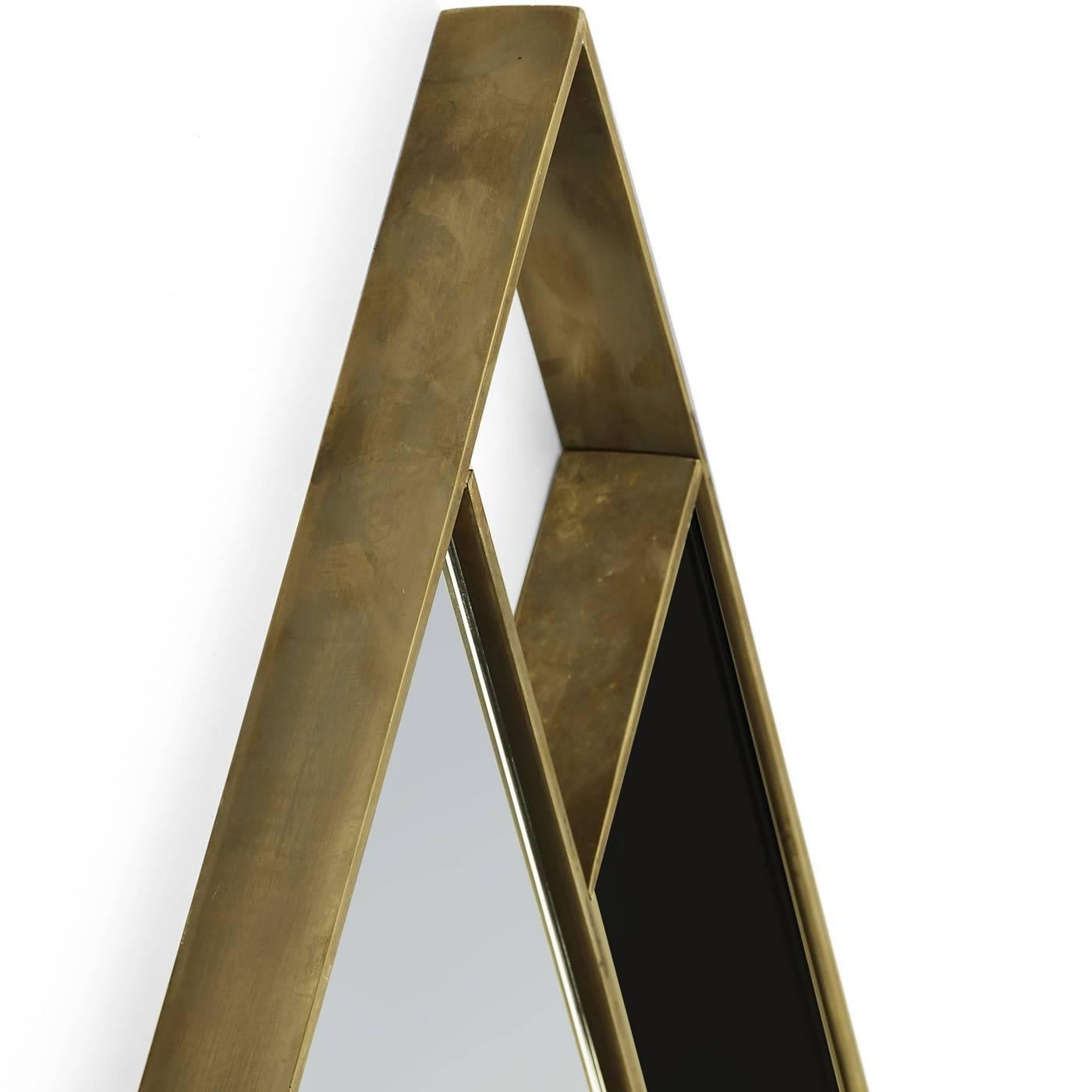 This decorative mirror has a striking diamond shape with a frame in brass and side accents in black glass.