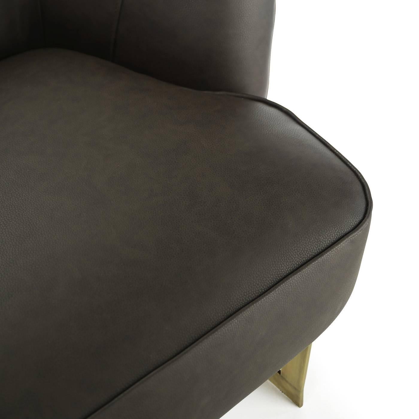 This elegant armchair, designed by Studio 63 for Marioni, features a brass structure and a polyurethane padding. It is available in different upholstery. In this configuration the cover is in dark brown leather .