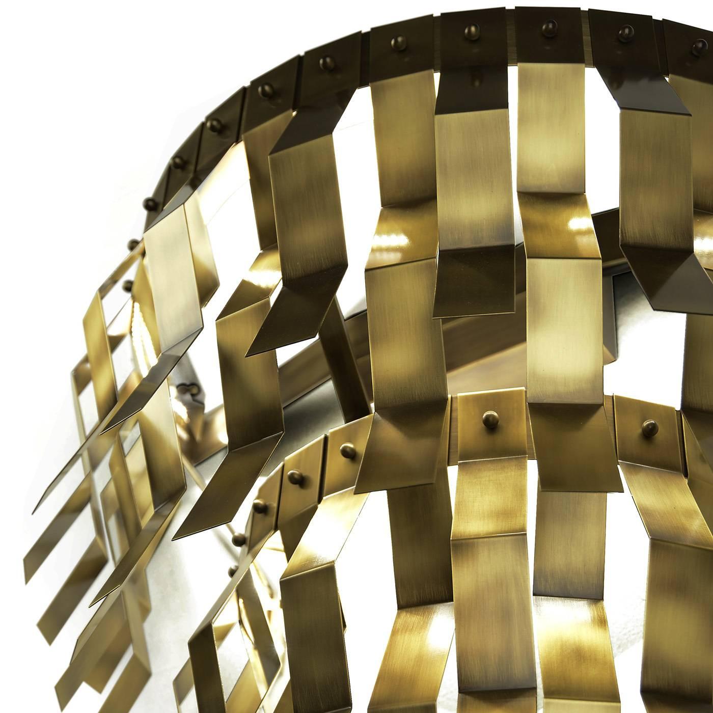 This striking brass sconce is decorated with geometrical metal accents that run all around its round perimeter and LED strip lighting.