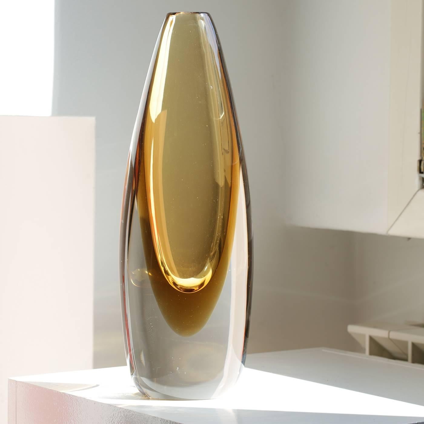 This striking mouth-blown vase features an elegant, elongated shape and is handcrafted in crystal and tobacco colors.

        