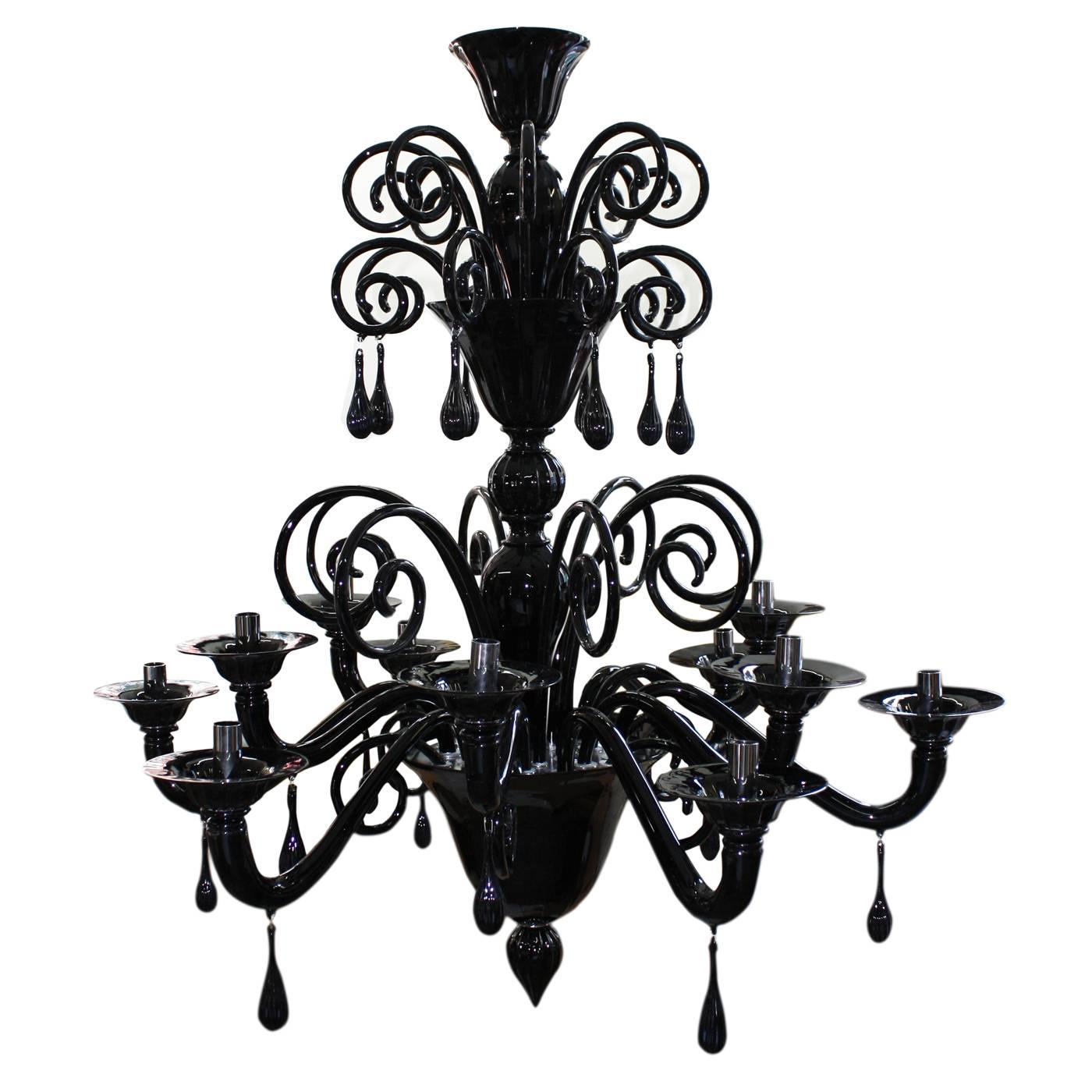 This majestic chandelier has twelve lights and can feature two or three tiers of lights. Each tier is decorated at the top with a series of curls with pendants. The same pendants adorn also the curve of each arm.